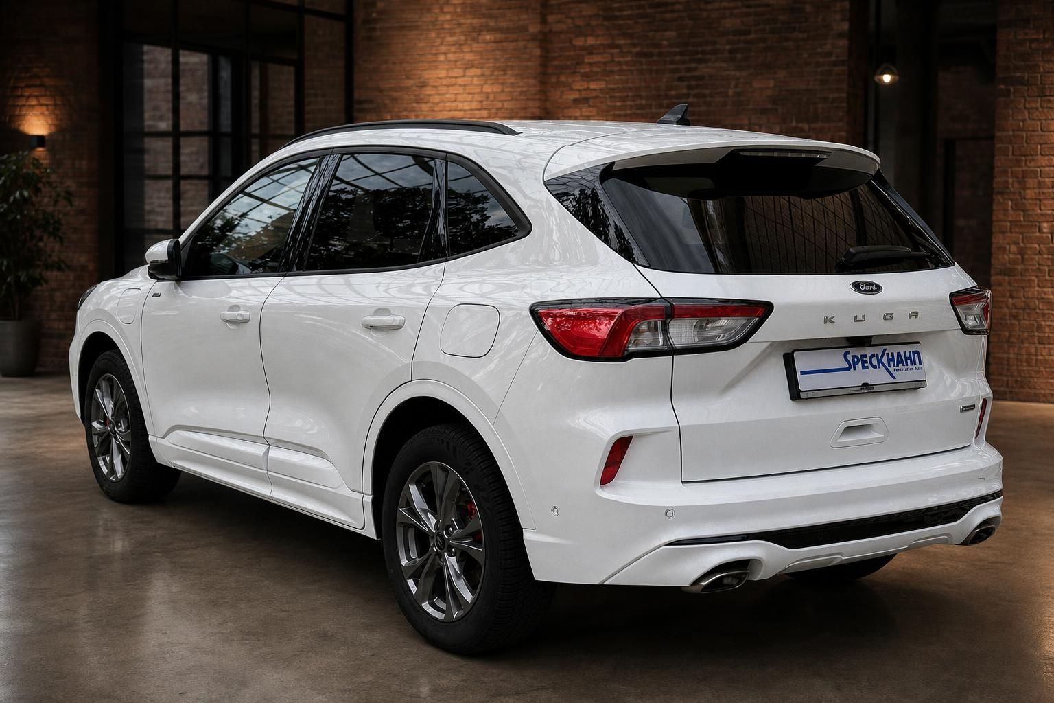 Ford Kuga weiß Heckansicht schräg mit Ziegelwand und Pflanze
