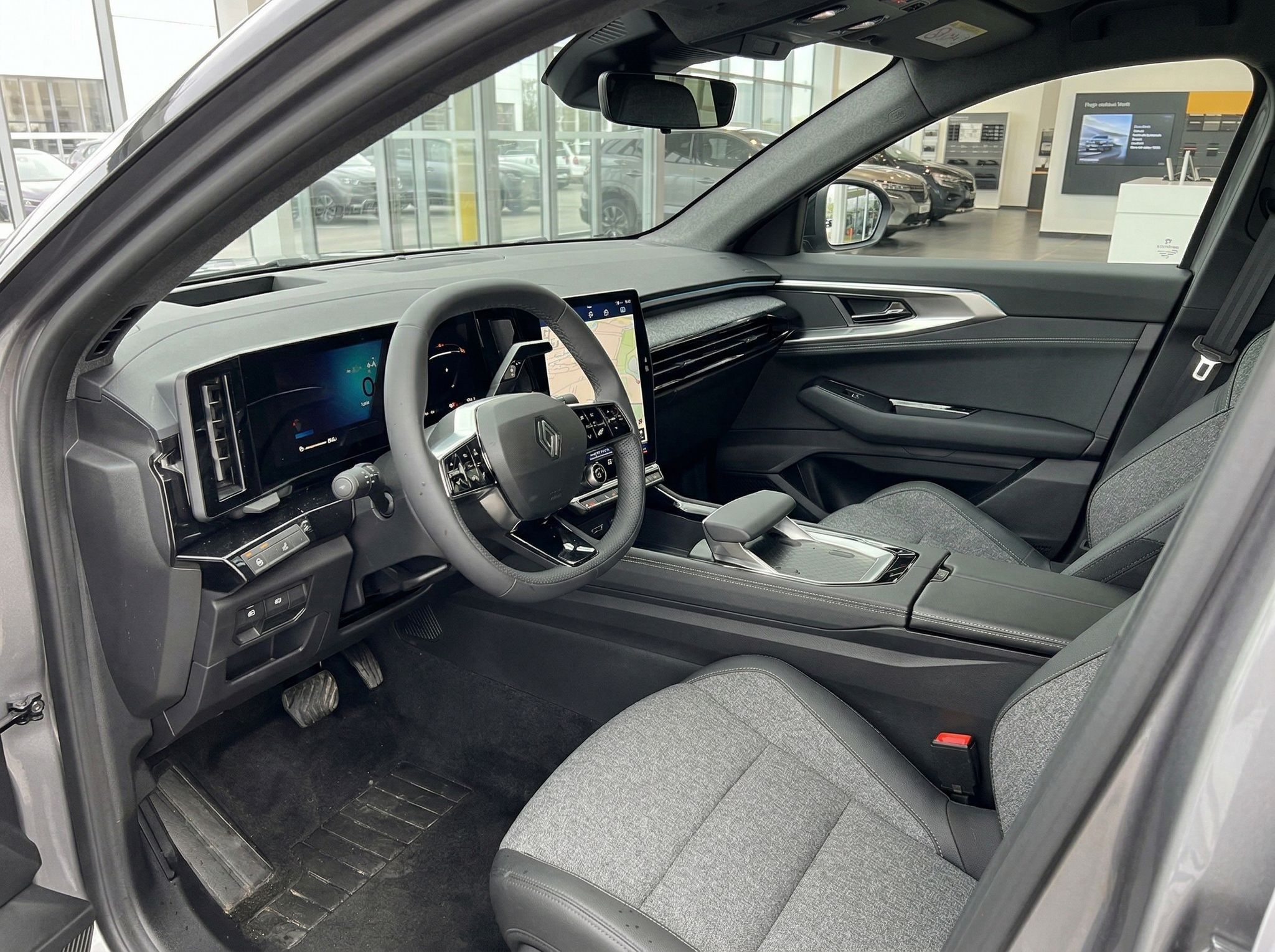 Modernes Fahrzeug-Cockpit mit digitalem Display und grauer Innenausstattung - Fahrersicht