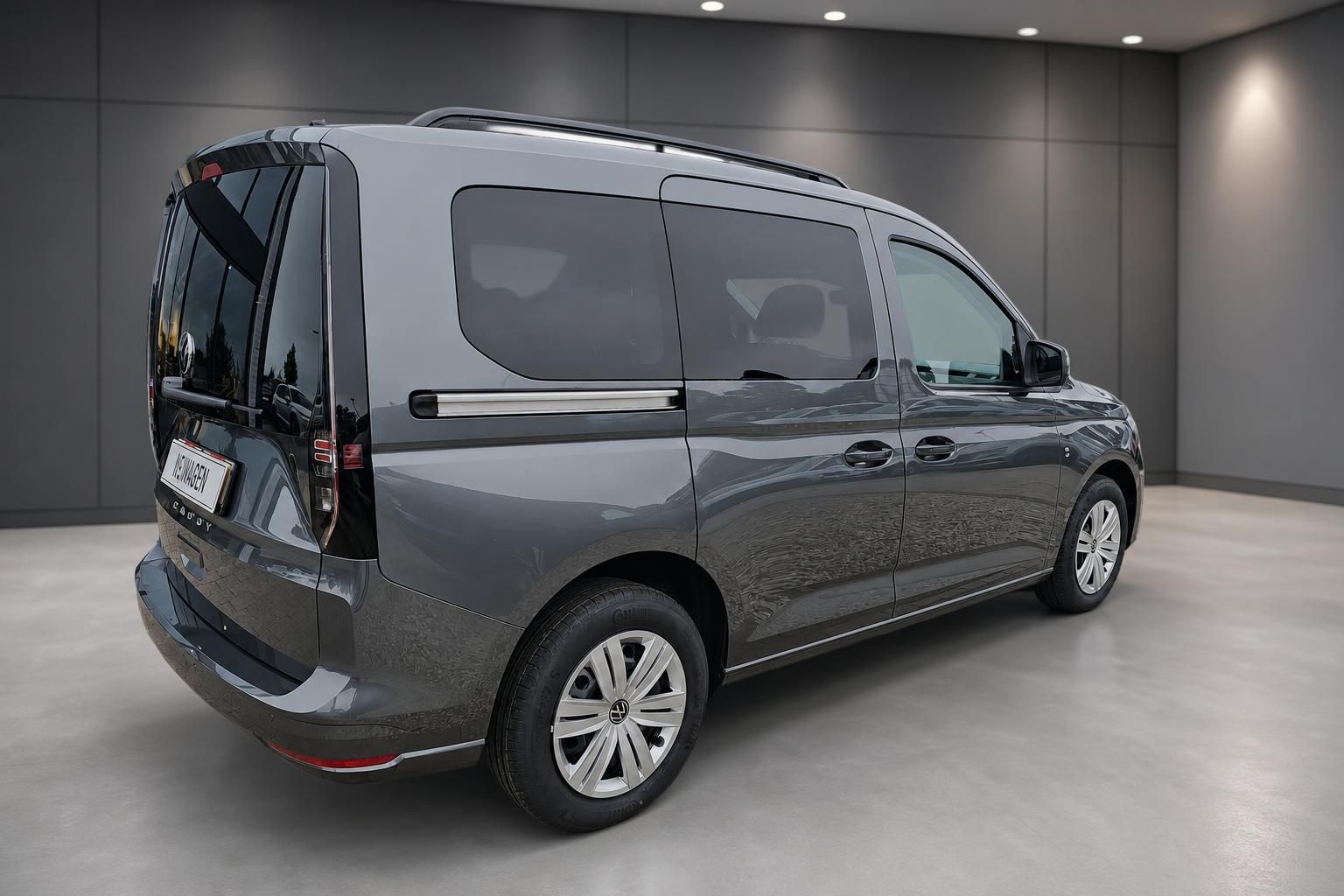 VW Caddy grau Seitenansicht schraeg von hinten
