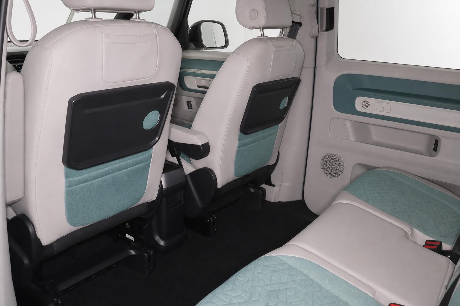 Innenraum VW Bus mit Klapptischen und mintfarbener Polsterung