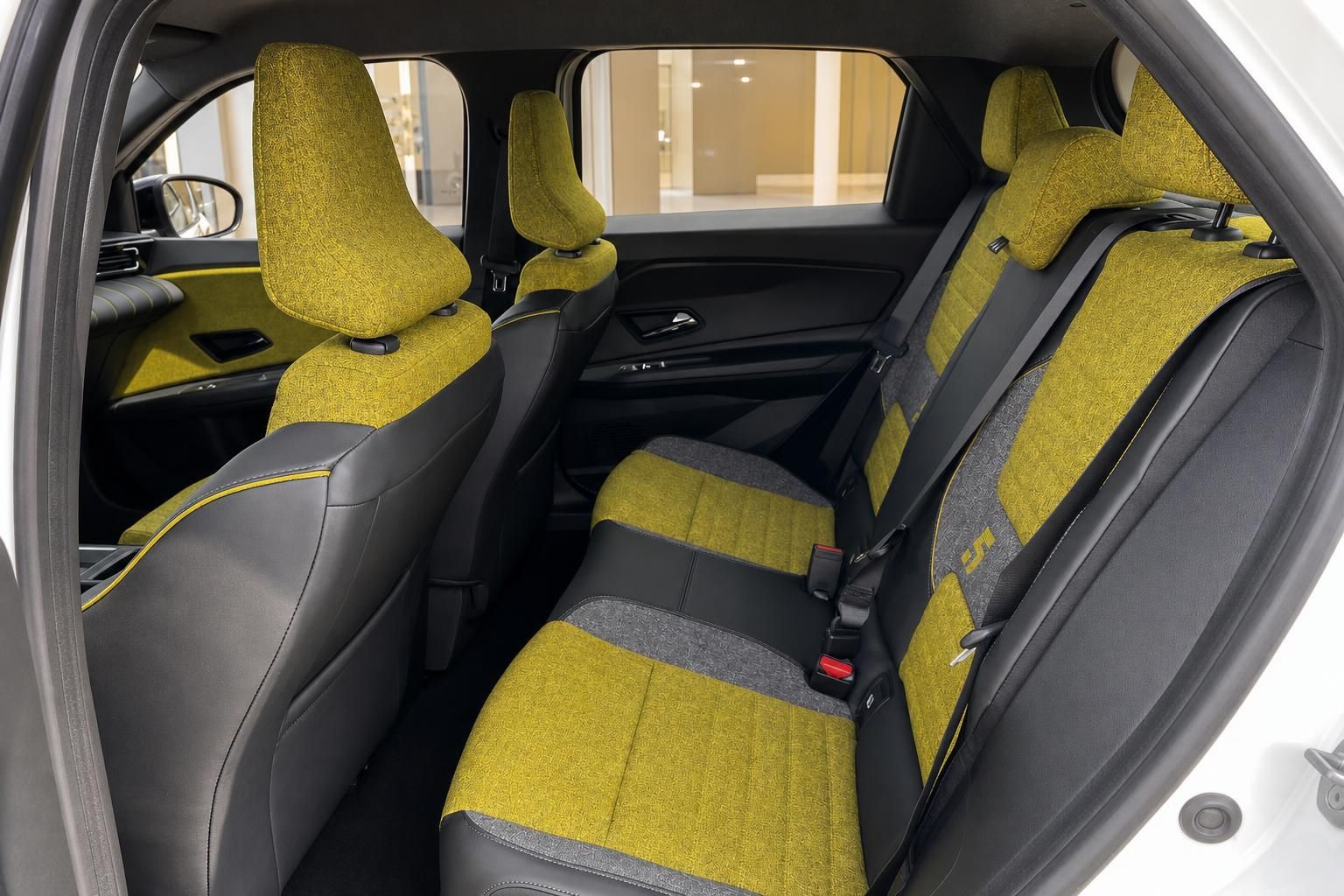 Rücksitzbereich mit gelb-schwarzer Polsterung und Sicherheitsgurten im Fahrzeuginterieur