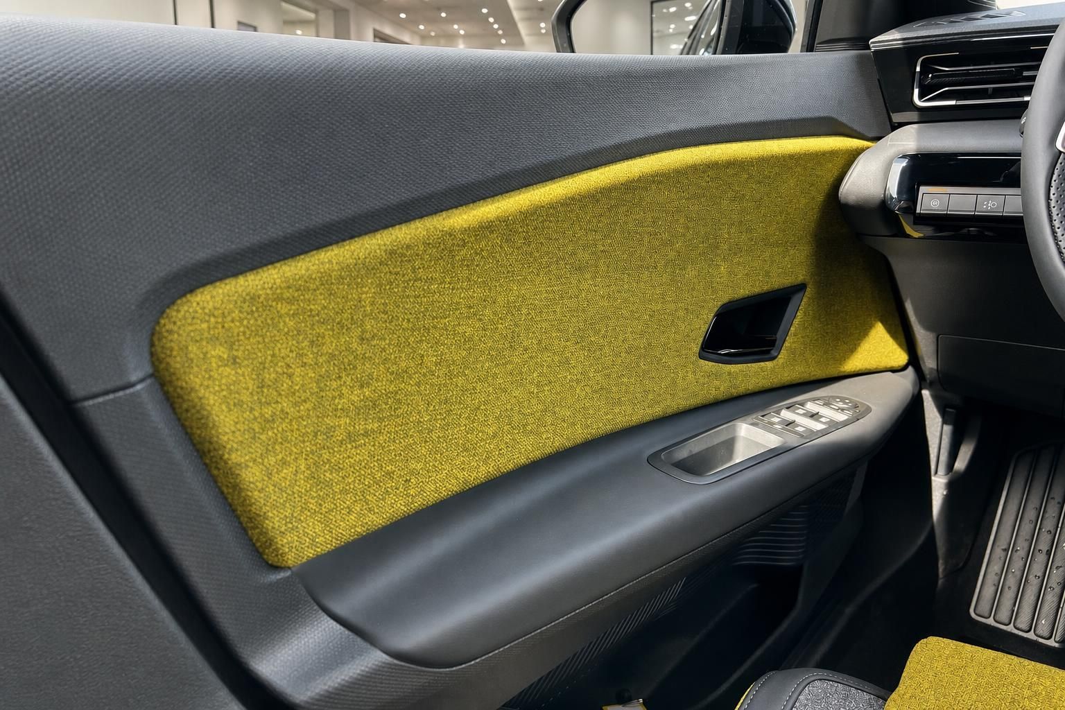 Türverkleidung mit gelber Stoffbespannung und Fensterheberschaltern im Fahrzeuginnenraum