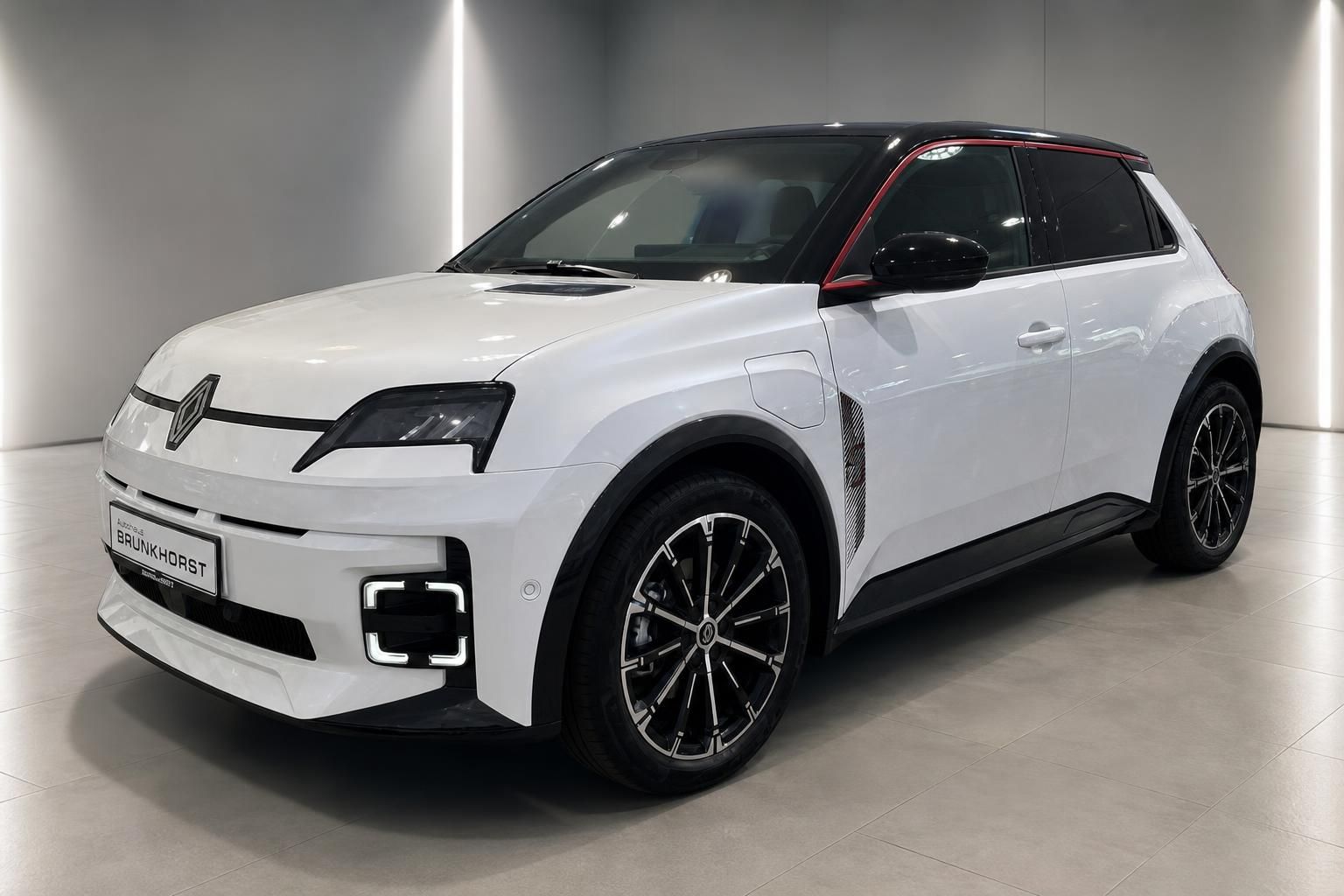 Weißer Renault Elektro-SUV Seitenansicht mit schwarzen Akzenten und modernen Alufelgen in Showroom-Beleuchtung