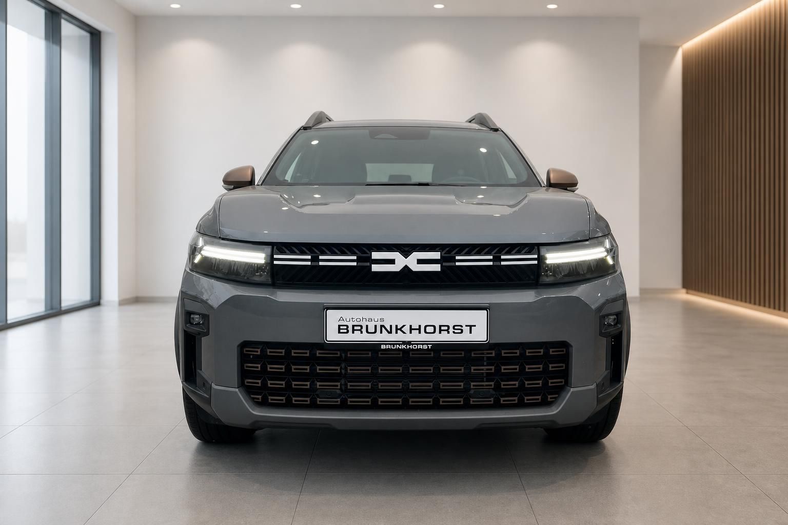 Dacia SUV Frontansicht in grau mit LED-Scheinwerfern im modernen Autohaus