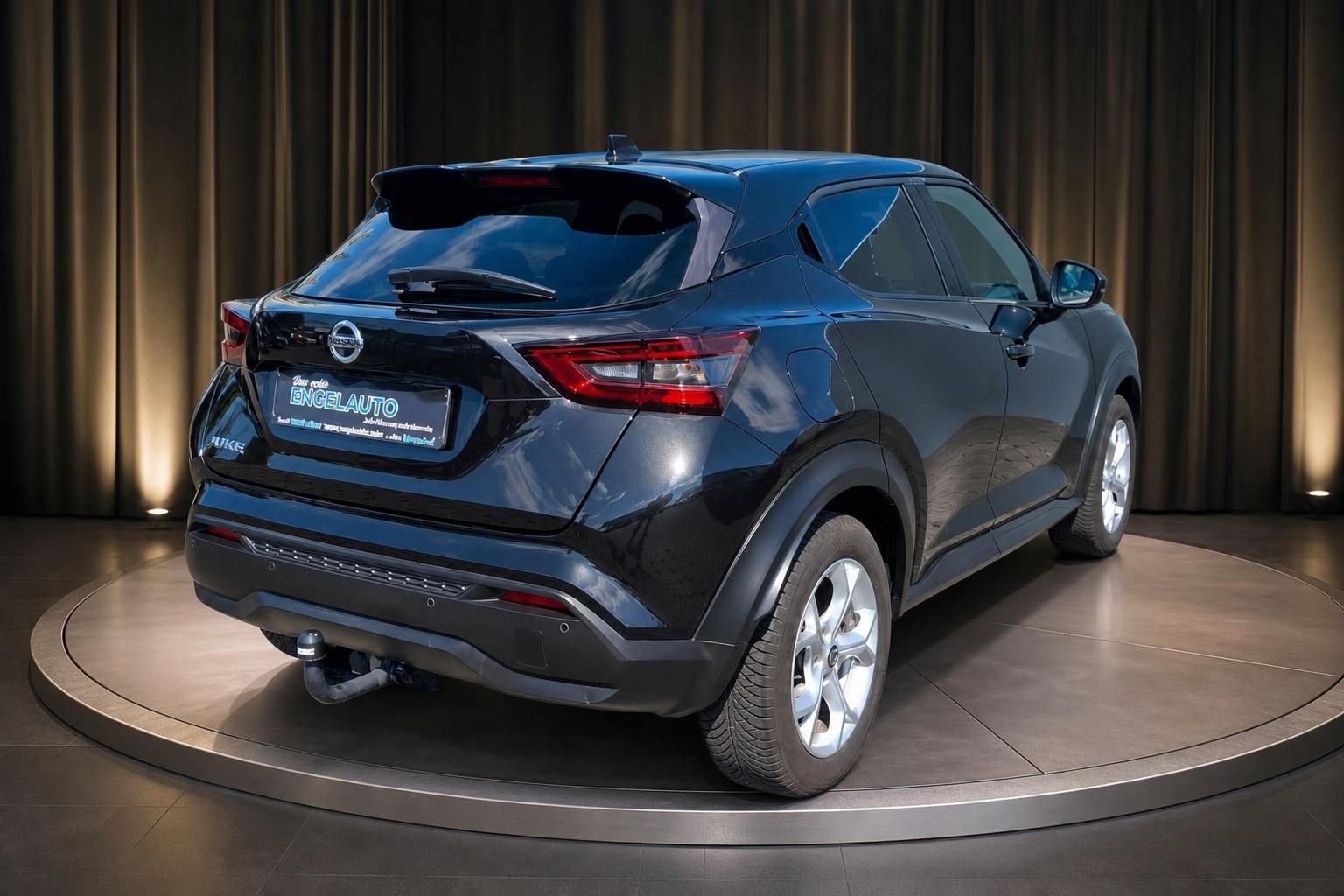 Nissan Juke schwarz Heckansicht mit Anhaengerkupplung im Showroom