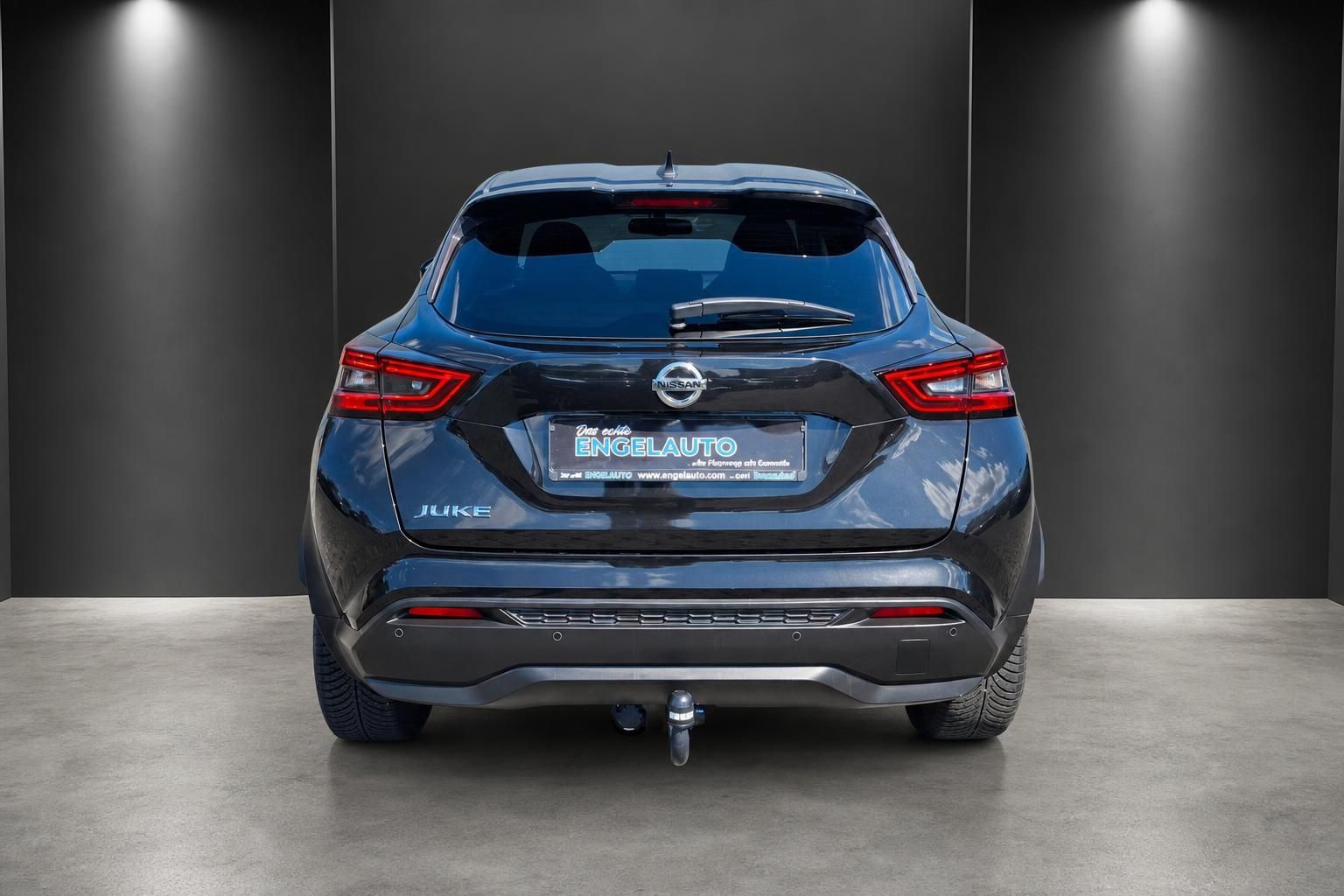 Nissan Juke in Blau-Metallic, Heckansicht mit Anhaengerkupplung im Studio