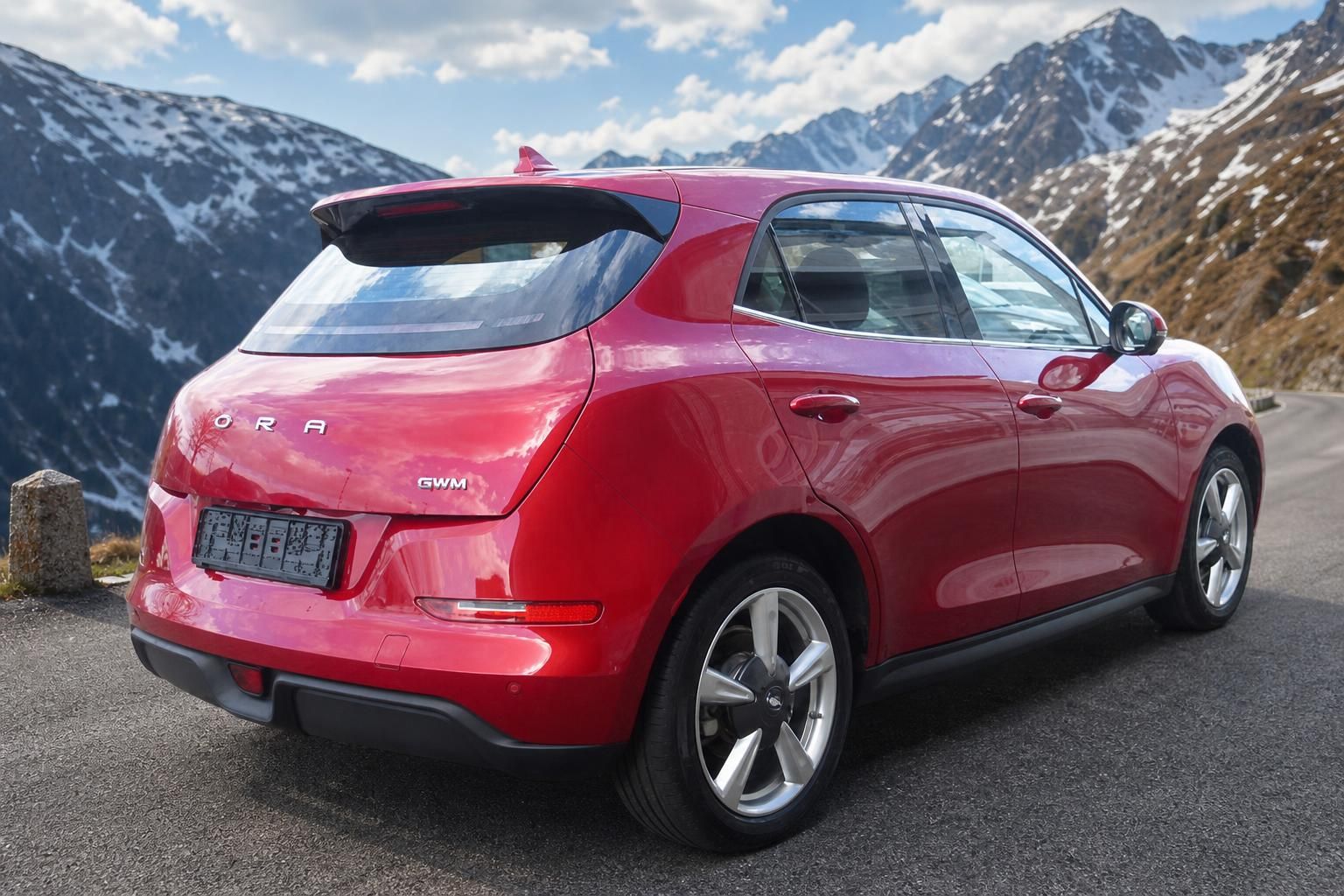 GWM ORA Elektroauto rot Heckansicht vor Bergpanorama mit Schnee