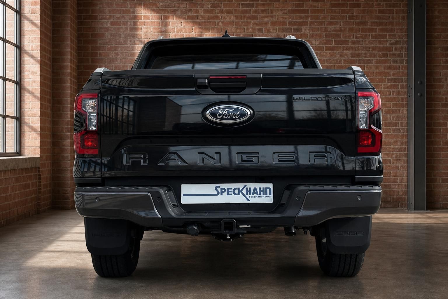 Ford Ranger Wildtrak schwarz direkte Heckansicht mit Anhängerkupplung im Showroom