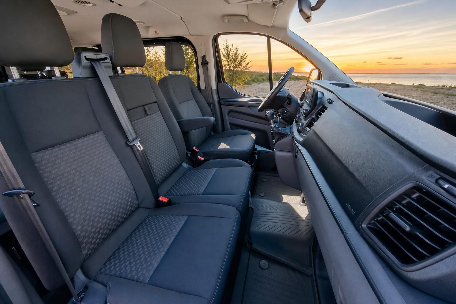 Ford Transit Van Innenraum mit Sitzreihen und Blick auf Sonnenuntergang am Strand