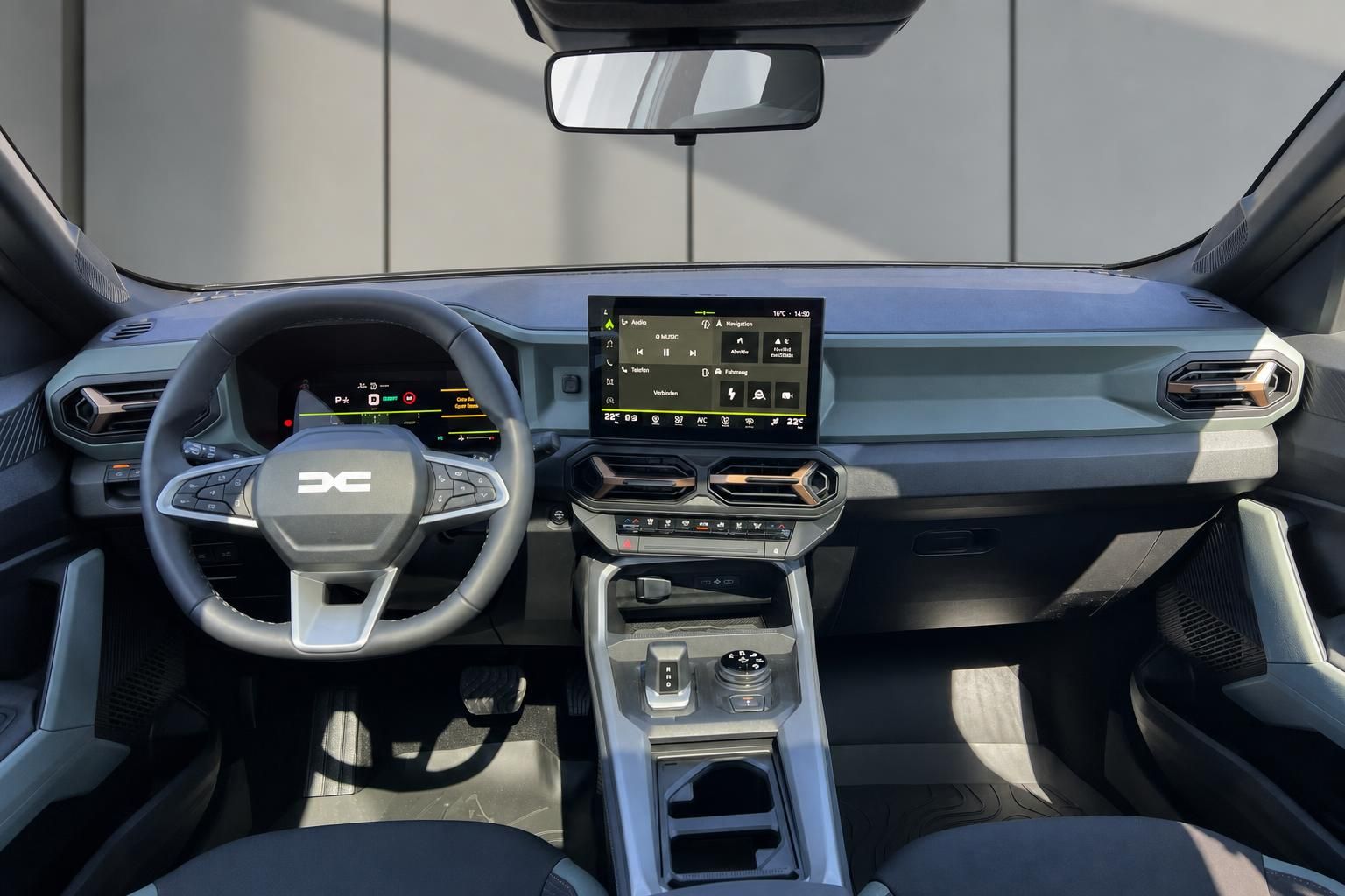 Modernes Fahrzeug-Cockpit mit digitalem Display, Lenkrad und Mittelkonsole in grauer Ausstattung