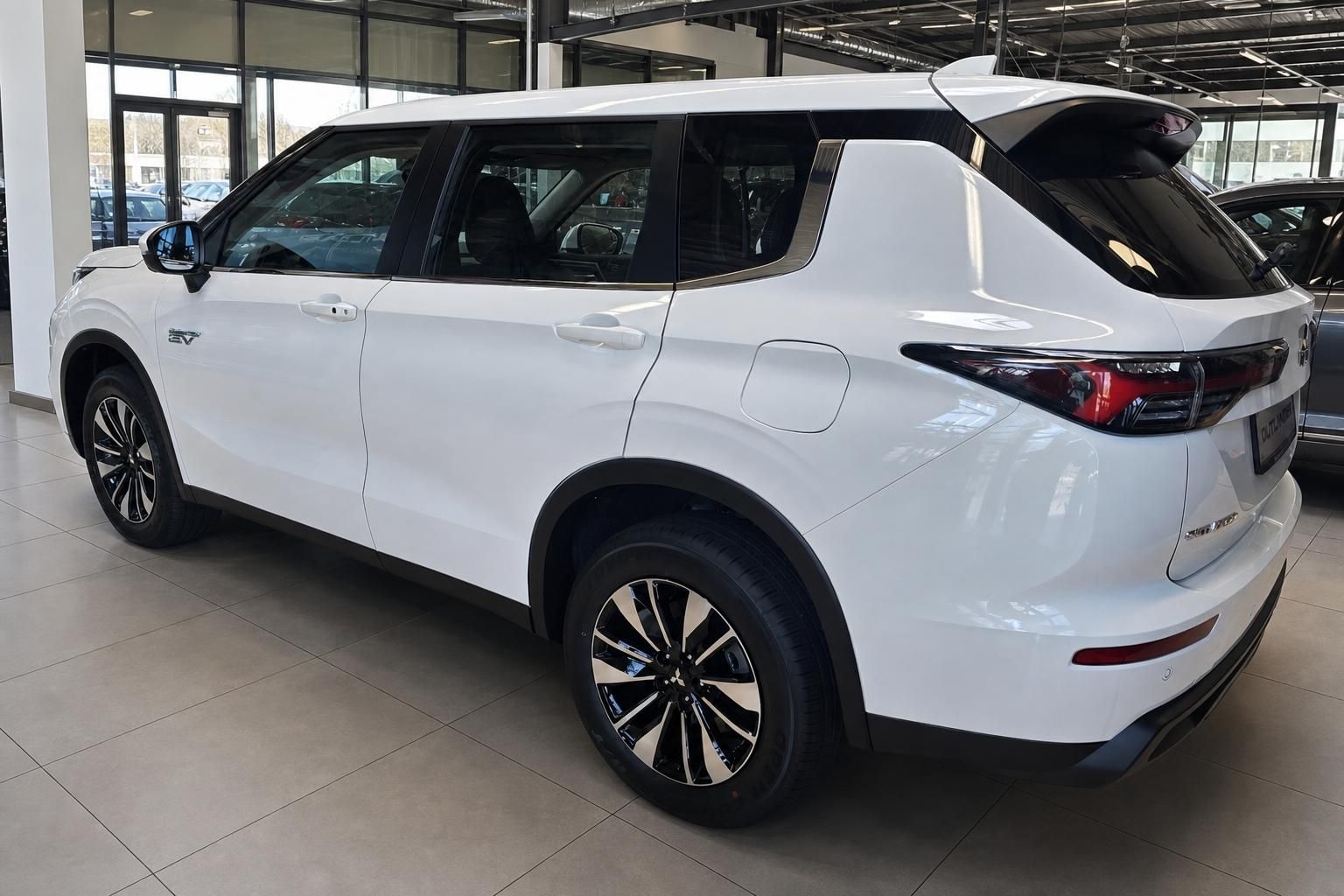 Mitsubishi Outlander PHEV in Weiß, Seitenansicht heck im Showroom