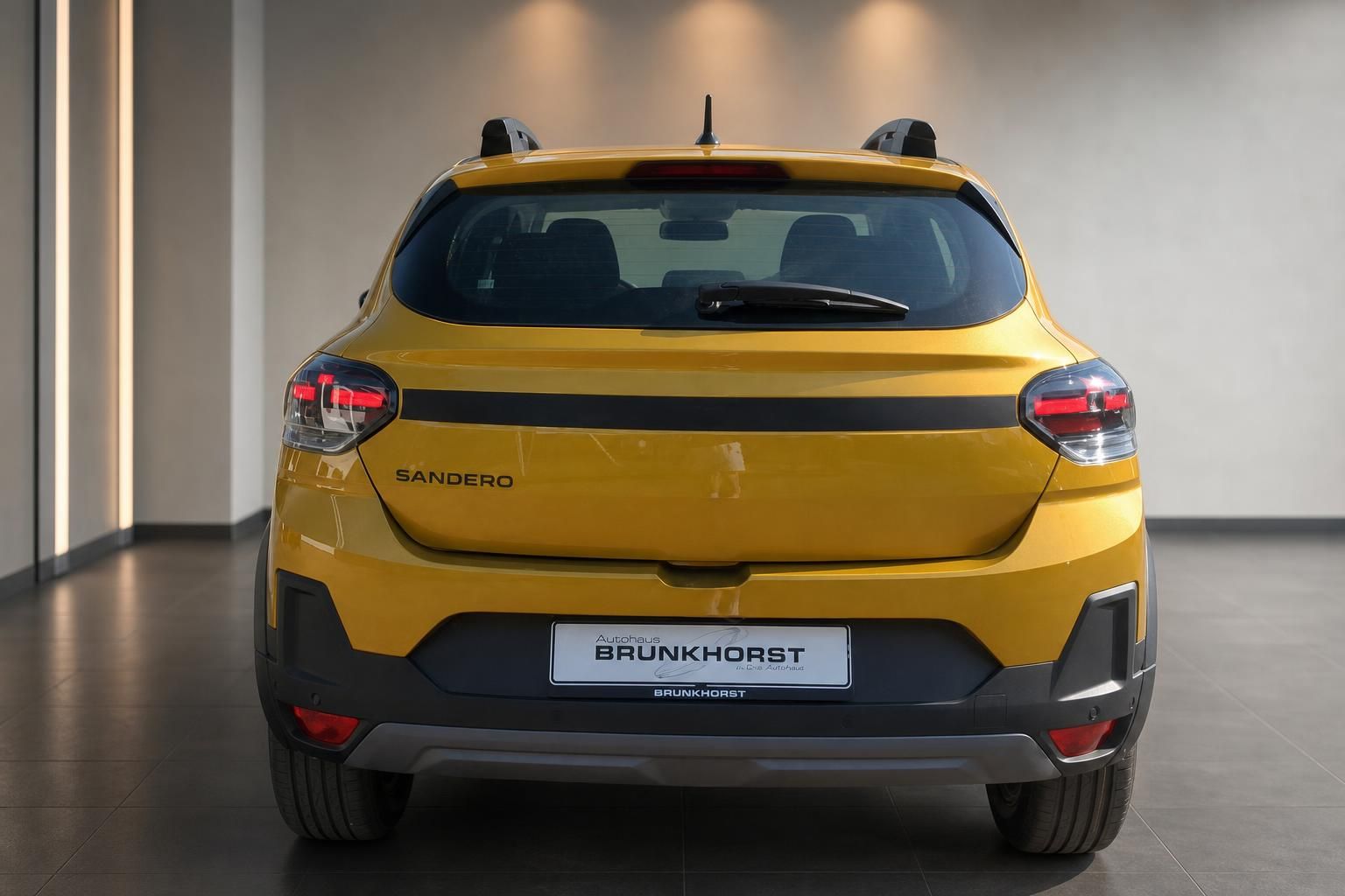 Dacia Sandero Stepway gelb Heckansicht mit LED-Rückleuchten im Autohaus