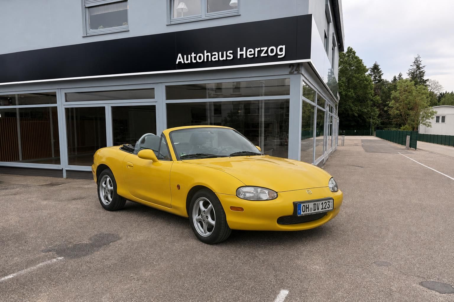 Gelber Mazda MX-5 Roadster Cabrio vor Autohaus Herzog - Sportwagen Gebrauchtwagen
