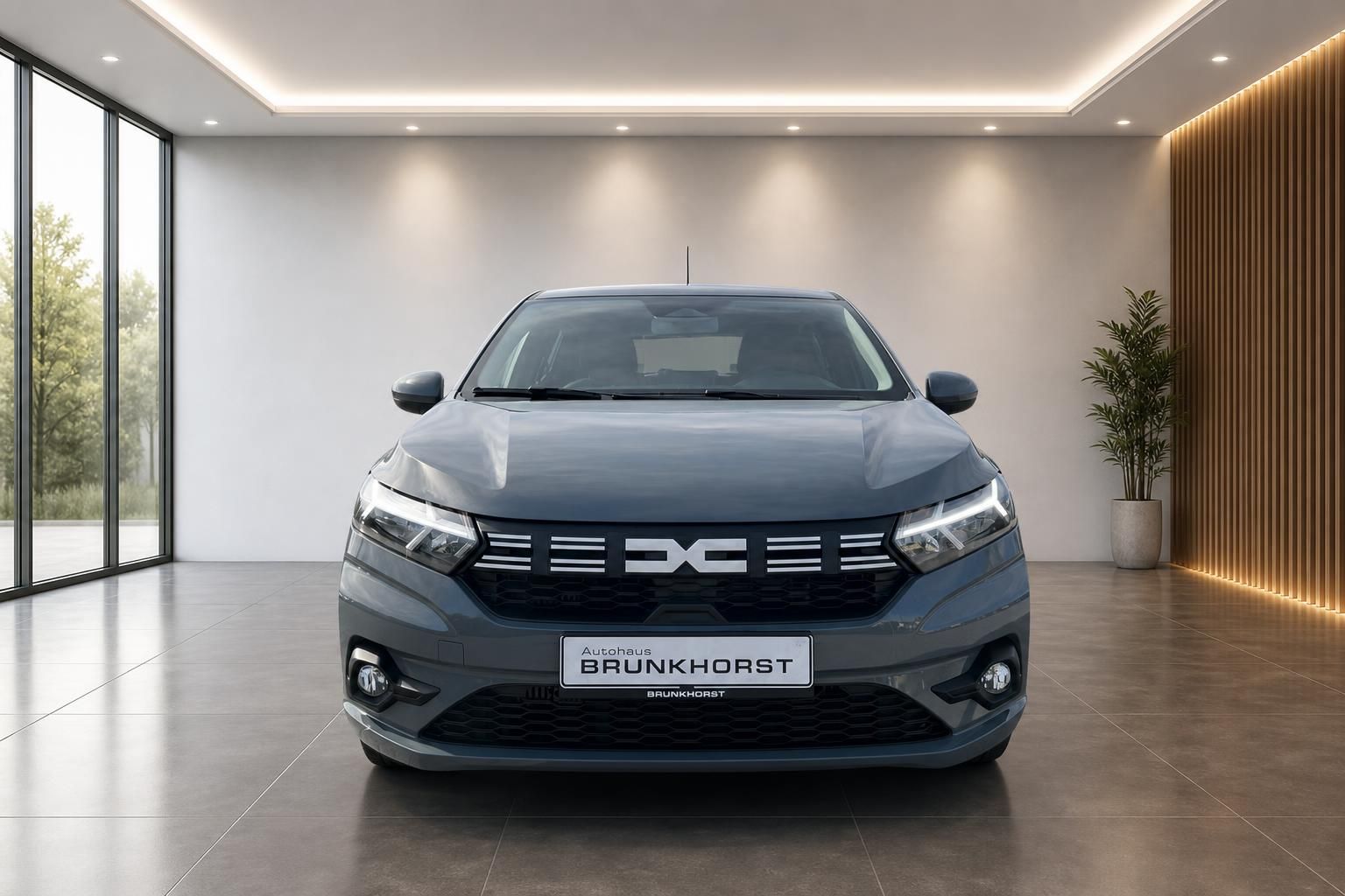Dacia Sandero grauer PKW Frontansicht mit LED-Scheinwerfern im eleganten Autohaus Showroom
