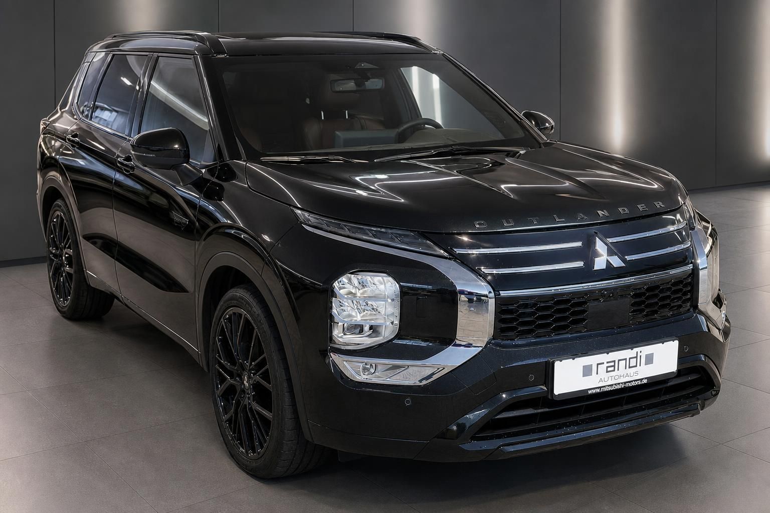 Mitsubishi Outlander schwarz 3/4-Frontansicht mit schwarzen Felgen im Autohaus Randi