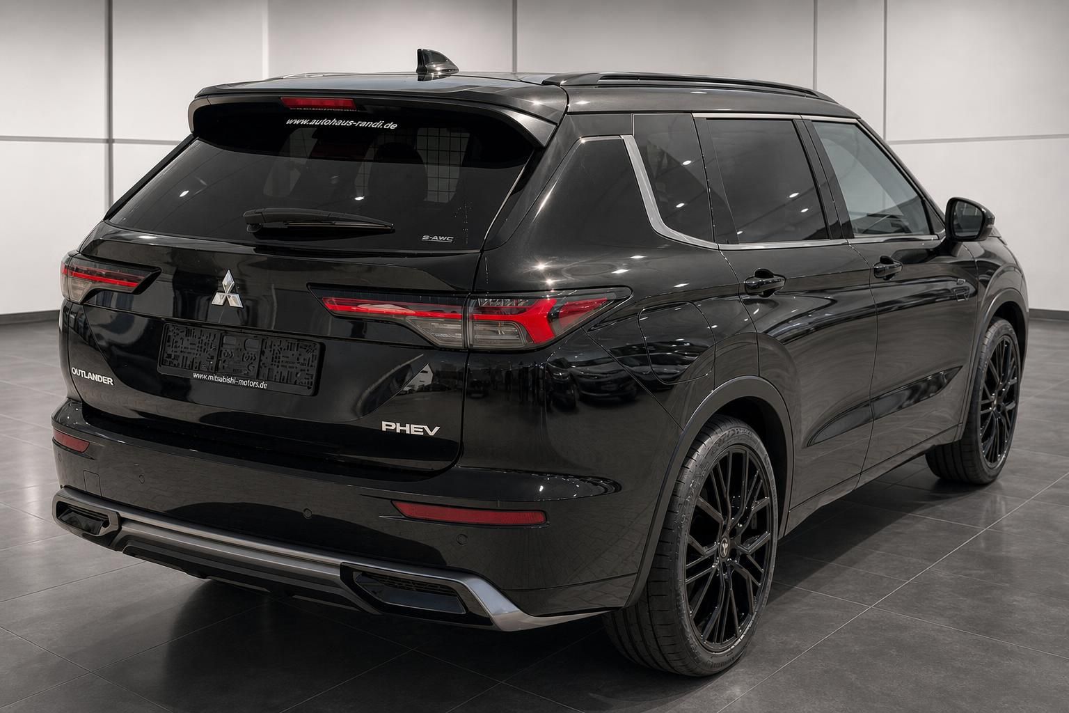 Mitsubishi Outlander PHEV schwarz Heckansicht schräg im Autohaus Showroom