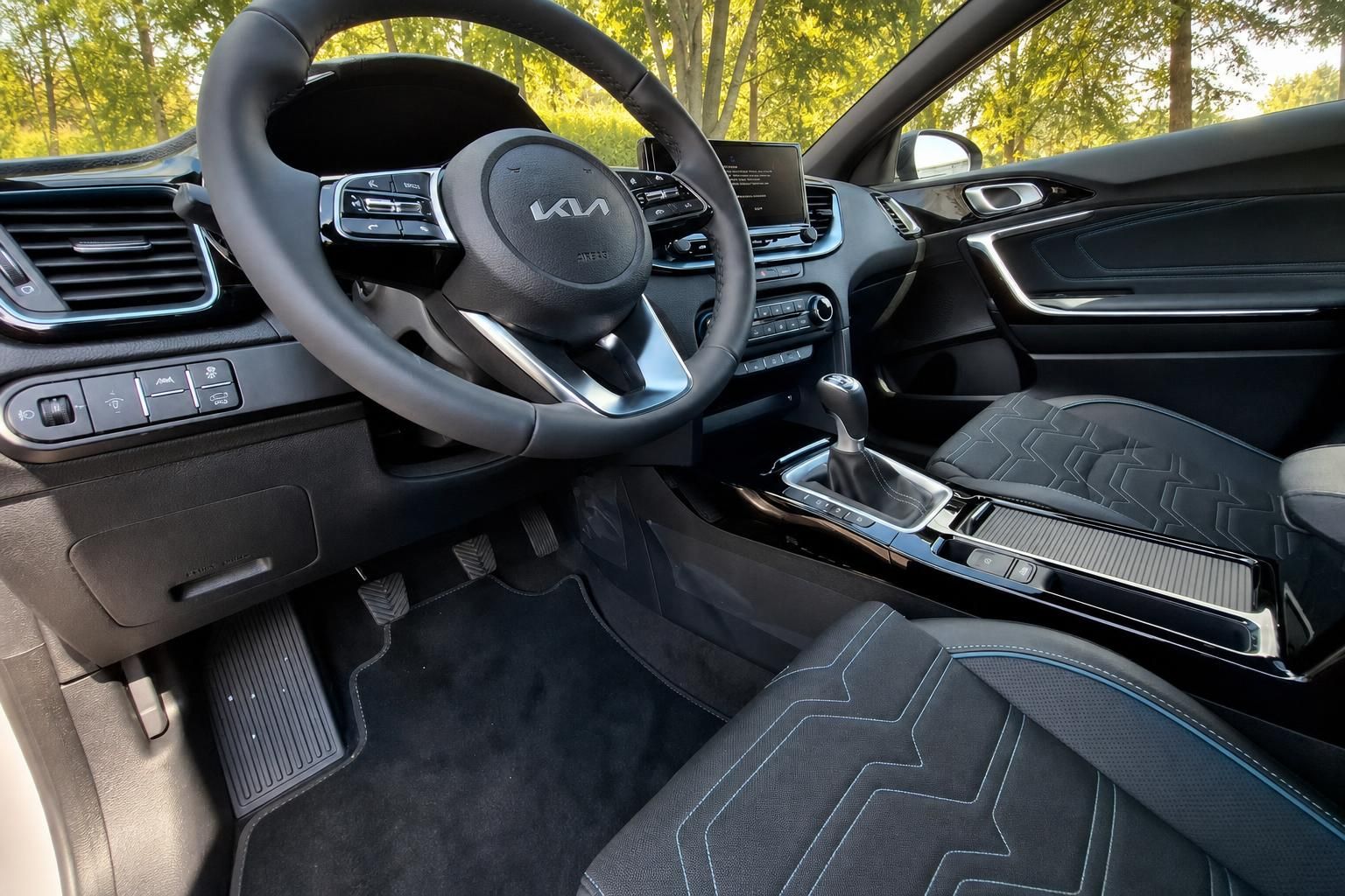Kia Fahrzeug Cockpit mit Lenkrad, Touchscreen und grauer Innenausstattung