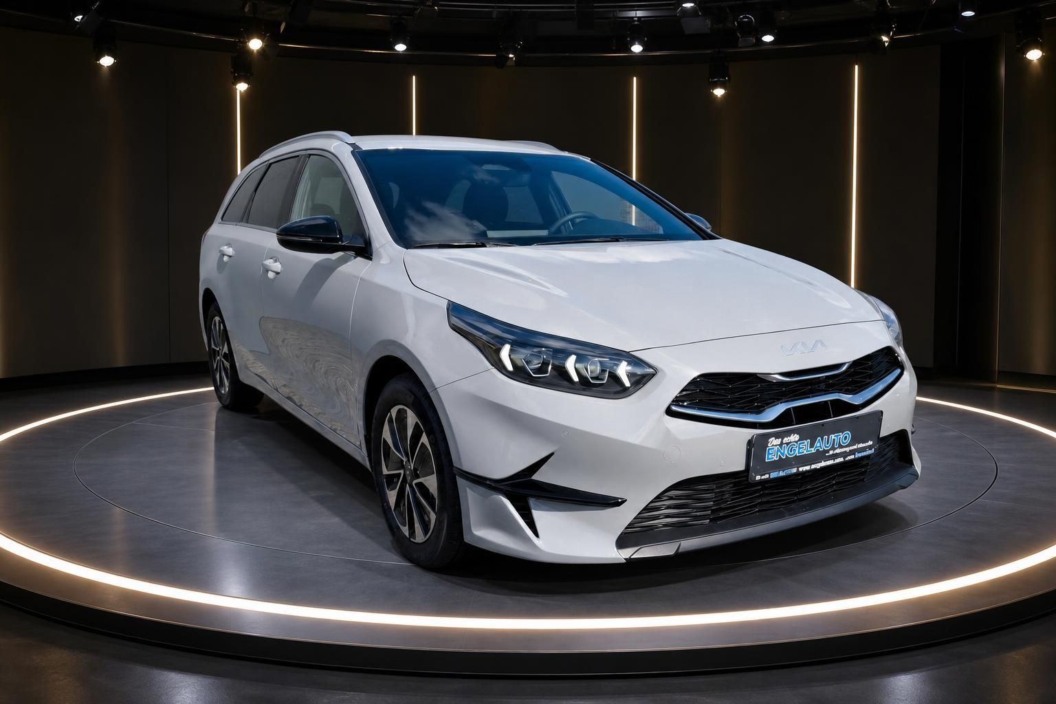 Weißer Kia Ceed Sportswagon im modernen Showroom - Seitenansicht mit LED-Scheinwerfern und Alufelgen