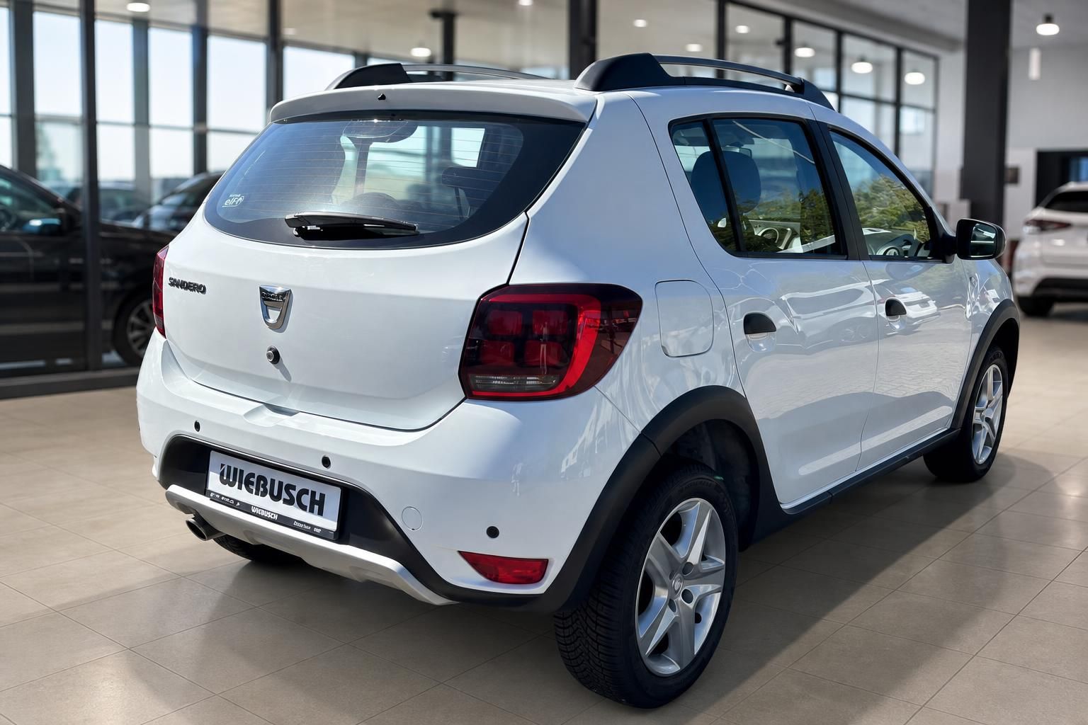 Dacia Sandero weiss Heckansicht schräg im Autohaus - moderner Kleinwagen mit Alufelgen