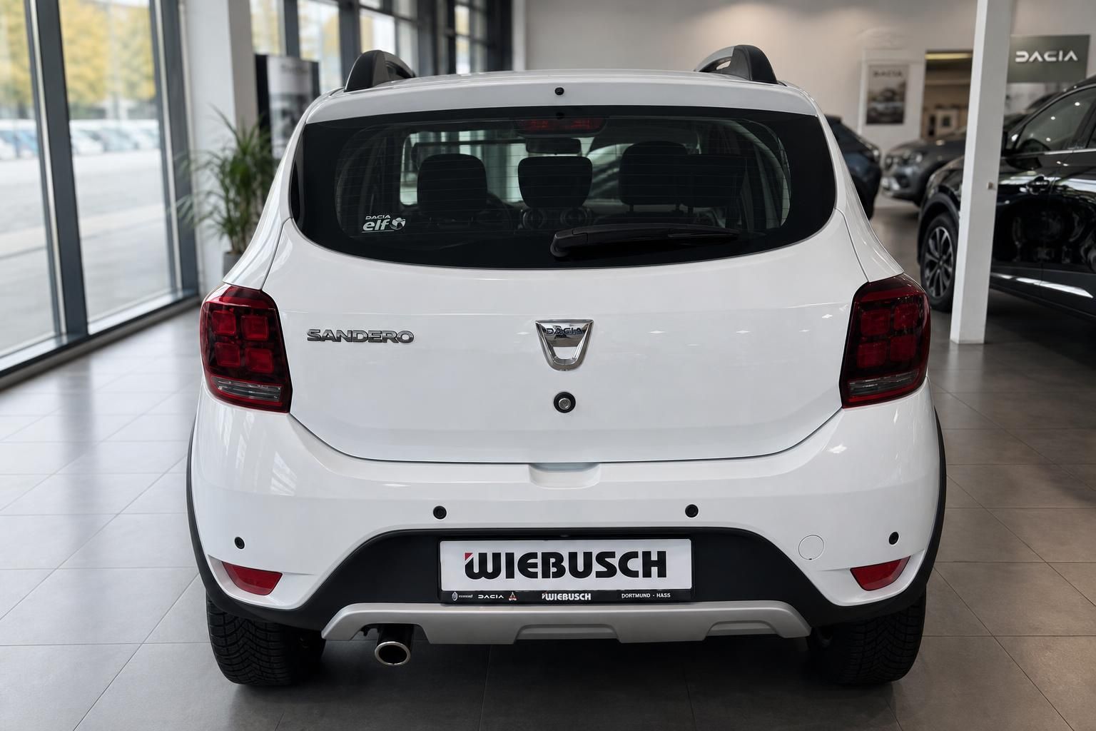 Dacia Sandero weiss Heckansicht gerade - kompakter Familienwagen im Autohaus Showroom