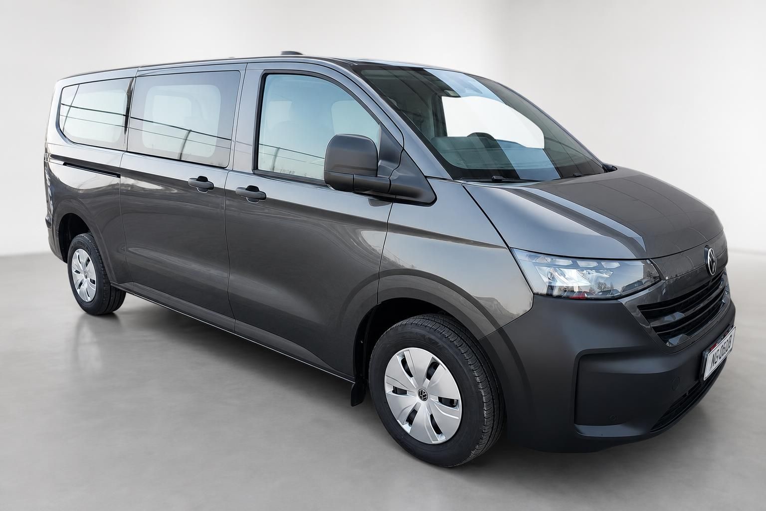 VW Caravelle grau Frontansicht schraeg Van vor weissem Hintergrund