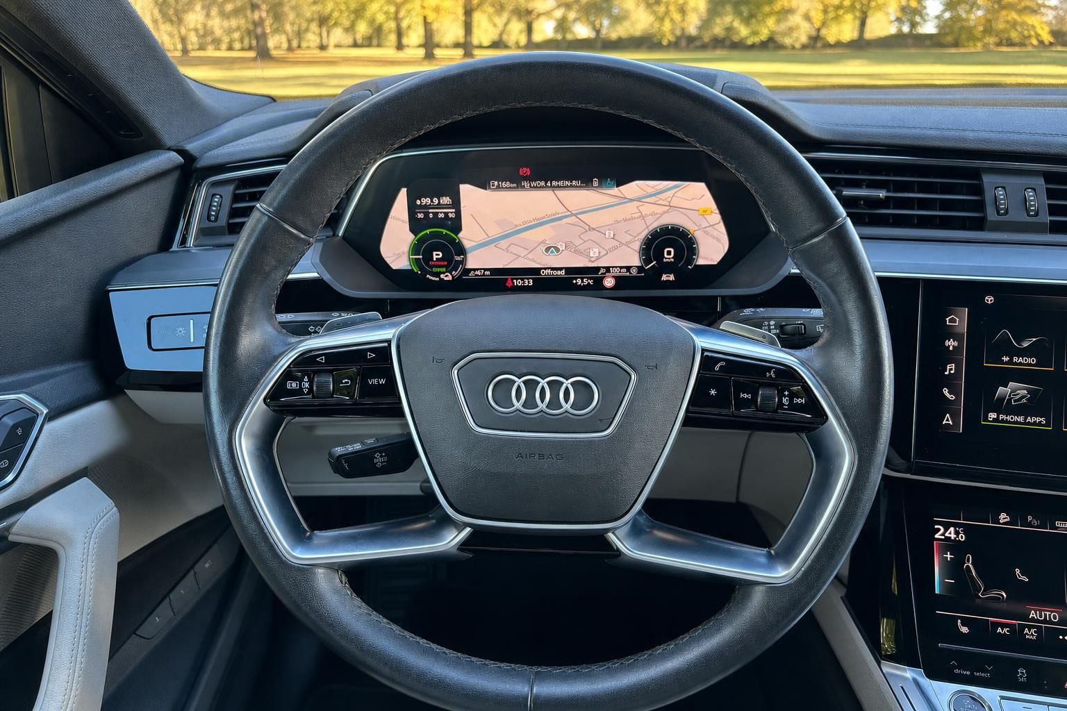 Audi Lenkrad mit digitalem Cockpit und Navigationssystem im Hintergrund