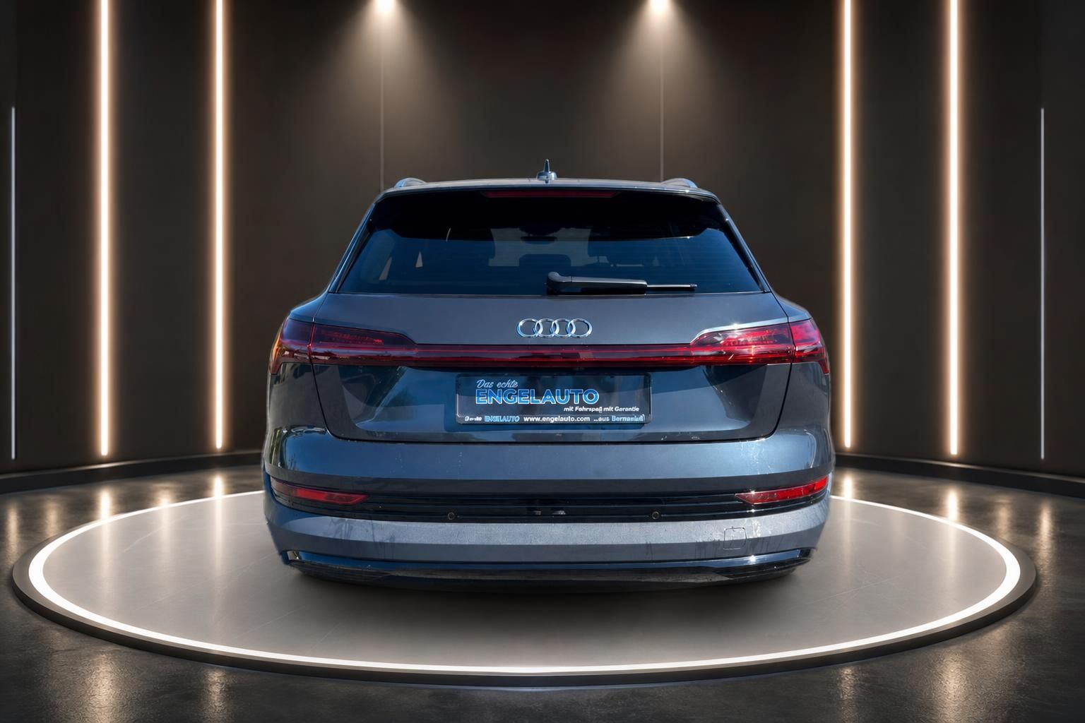 Audi e-tron Heckansicht grau metallic mit Händlerkennzeichen im Showroom