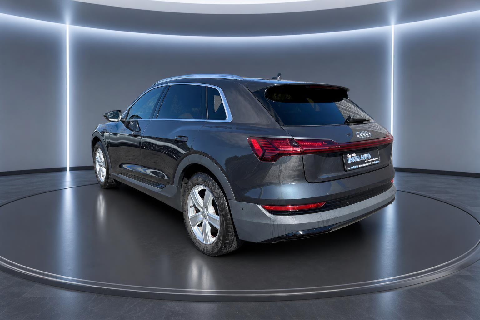 Audi e-tron Schrägheckansicht grau metallic auf Drehplattform im modernen Showroom