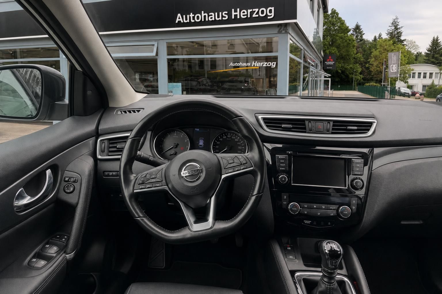 Nissan Qashqai Innenraum mit Armaturenbrett und Schaltgetriebe vor Autohaus Herzog