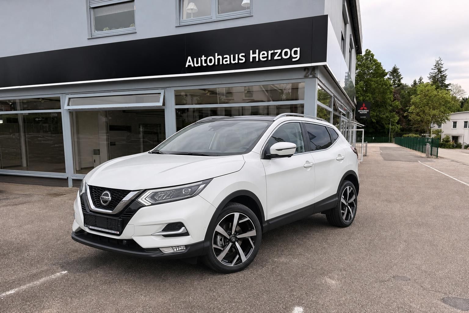 Weißer Nissan Qashqai SUV Frontansicht vor dem Autohaus Herzog geparkt