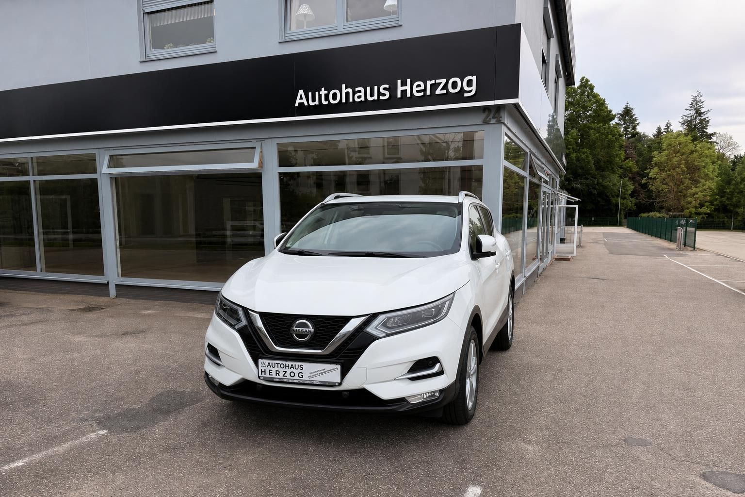 Nissan Qashqai in Weiß, Frontansicht vor Autohaus