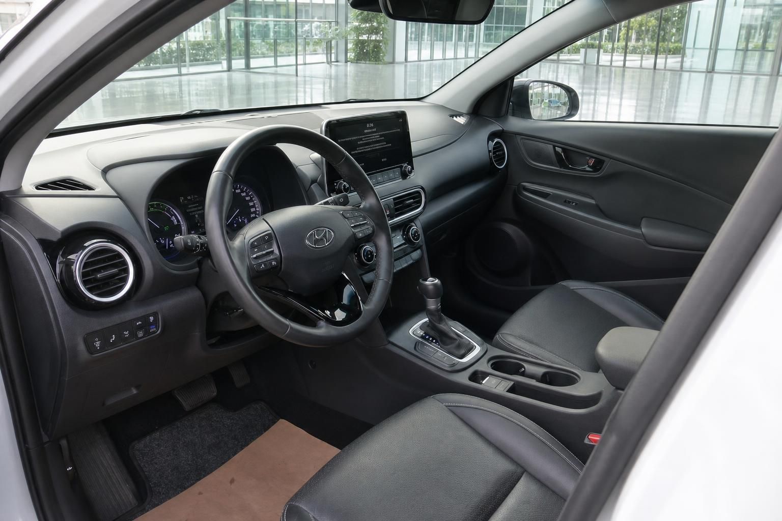 Hyundai Kona Hybrid Innenraum Fahrerseite mit Lenkrad, Automatikgetriebe und schwarzem Lederausstattung