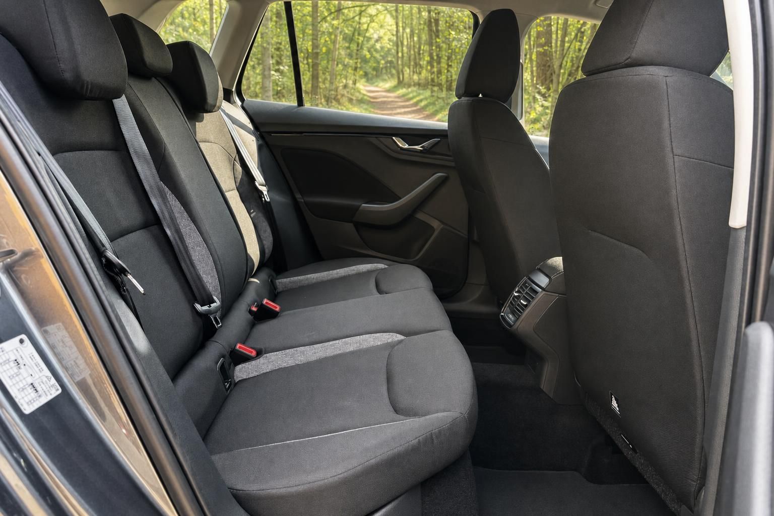 Skoda Kamiq Fond-Innenraum mit grauen Sitzen, Sicherheitsgurten und Panoramablick durch Seitenfenster