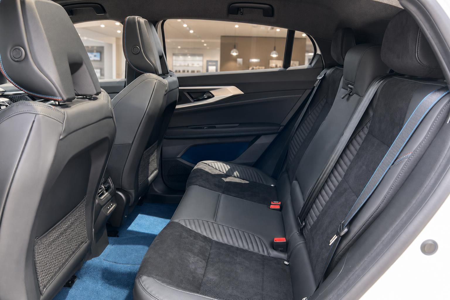 Fahrzeug Rücksitzbank schwarzes Leder mit blauem Teppich und Sicherheitsgurten