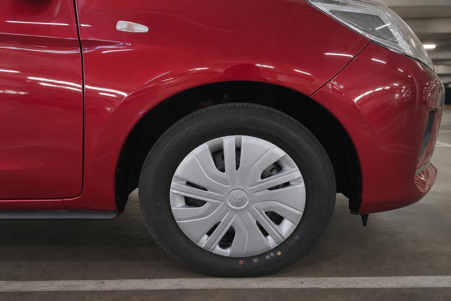 Mitsubishi Space Star rot – Detailaufnahme Vorderrad mit Radkappe in Parkhaus