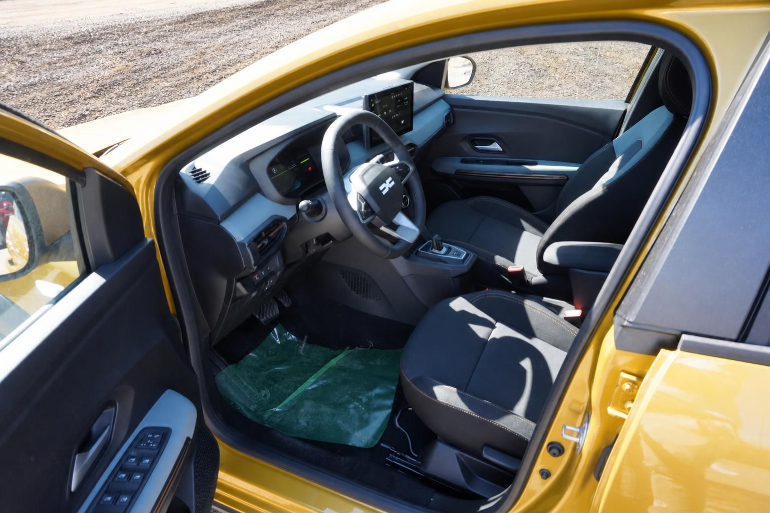 Dacia Sandero Innenraum gelb: Cockpit, Lenkrad, Touchscreen und Vordersitze von Fahrerseite