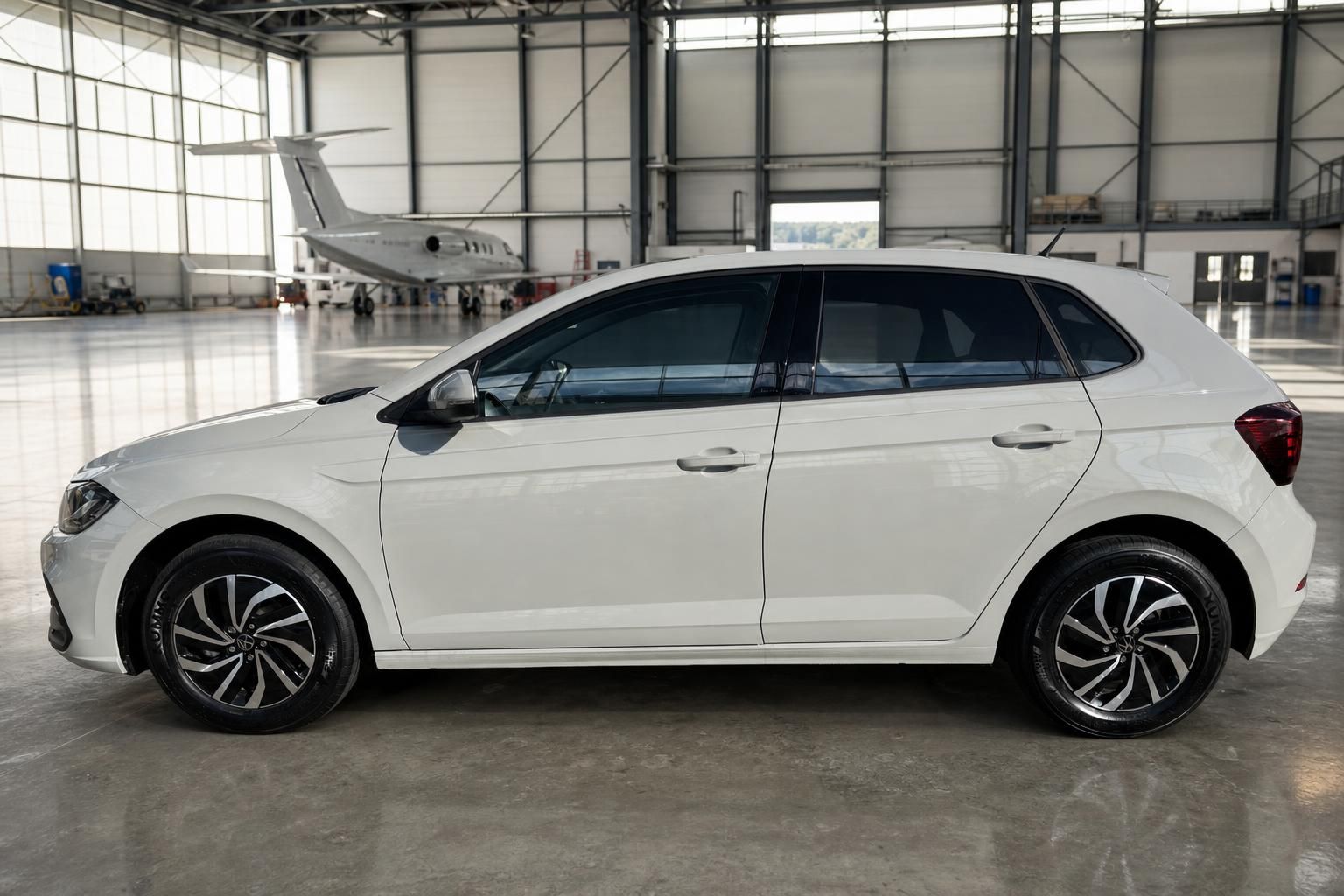 Weißer Volkswagen Polo Seitenansicht in Flugzeughalle mit Alufelgen