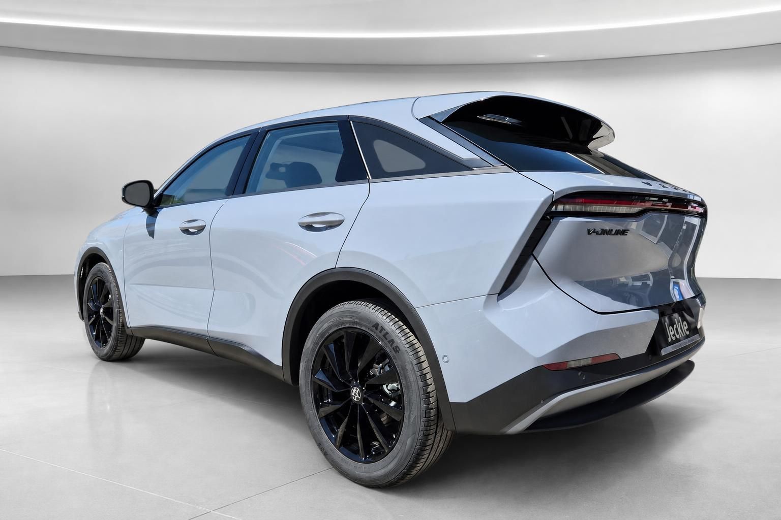Weißes SUV Coupé mit V-Inline Schriftzug, Heckansicht seitlich