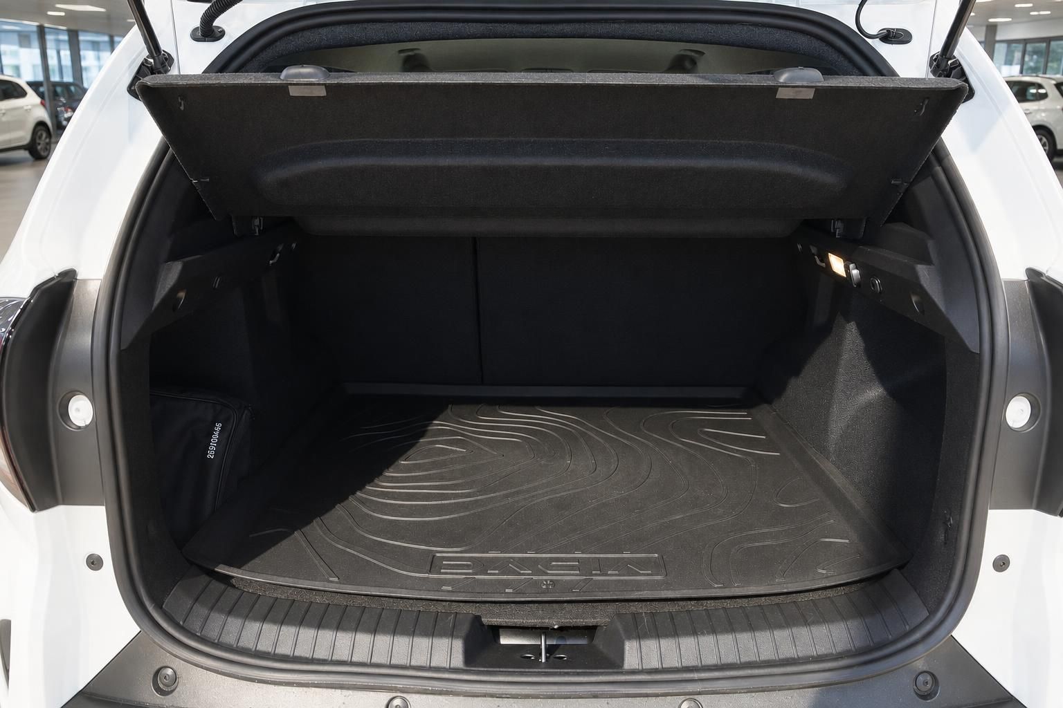 Kofferraum eines weißen Fahrzeugs mit schwarzer Gummimatte und geöffneter Heckklappe im Autohaus