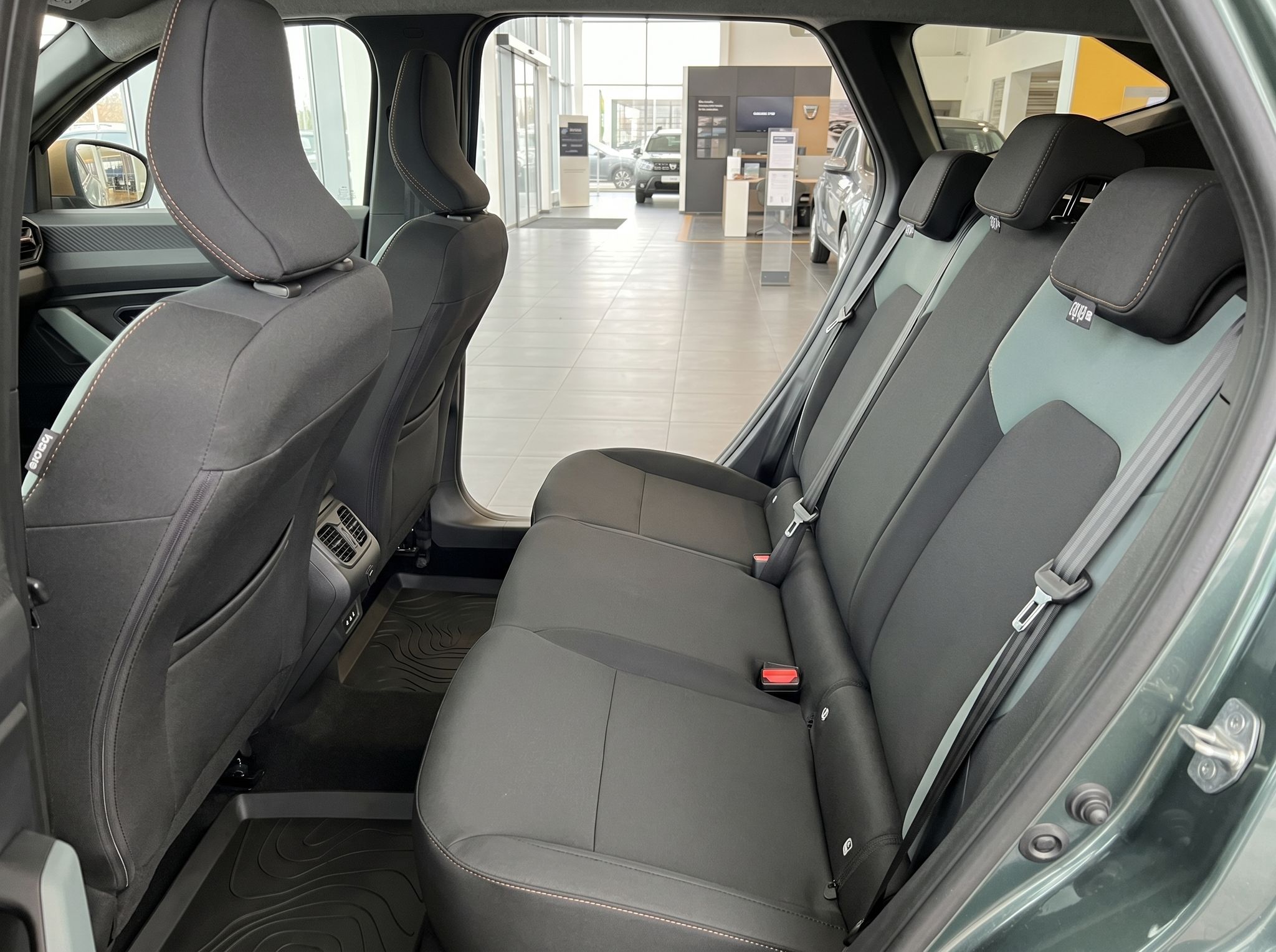 Geräumiger Rücksitzbereich mit drei Plätzen und grauen Polstern im Fahrzeuginnenraum