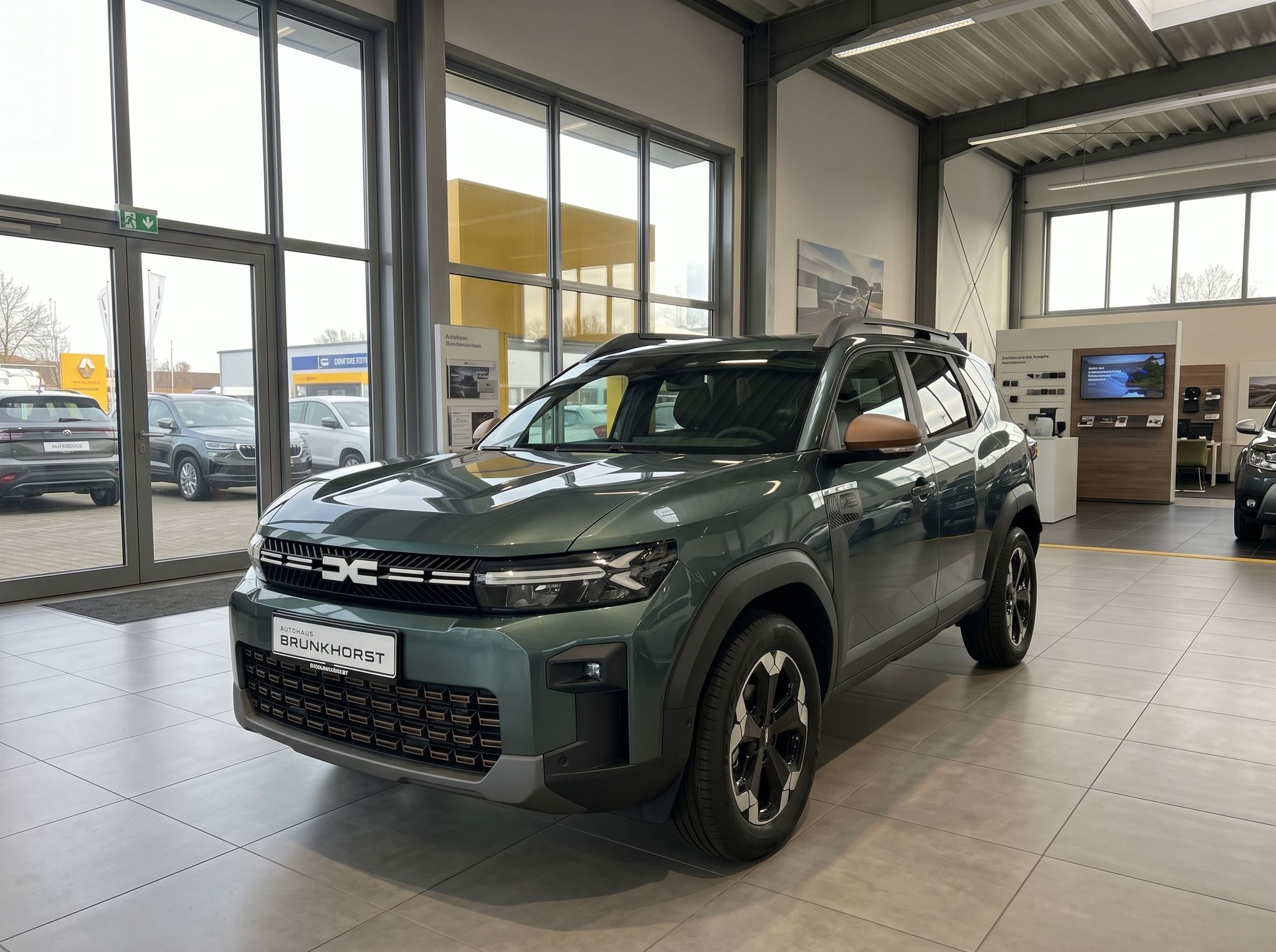 Dacia Bigster SUV in grün im Autohaus Showroom - Seitenansicht mit modernem Design