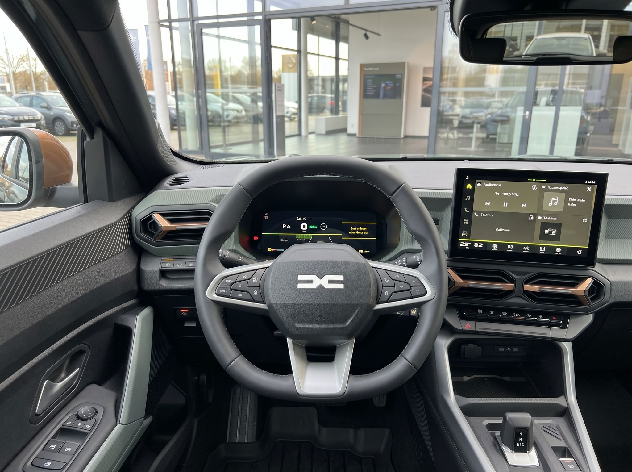 Fahrzeug-Innenraum mit Lenkrad, digitalem Armaturenbrett und Infotainment-System