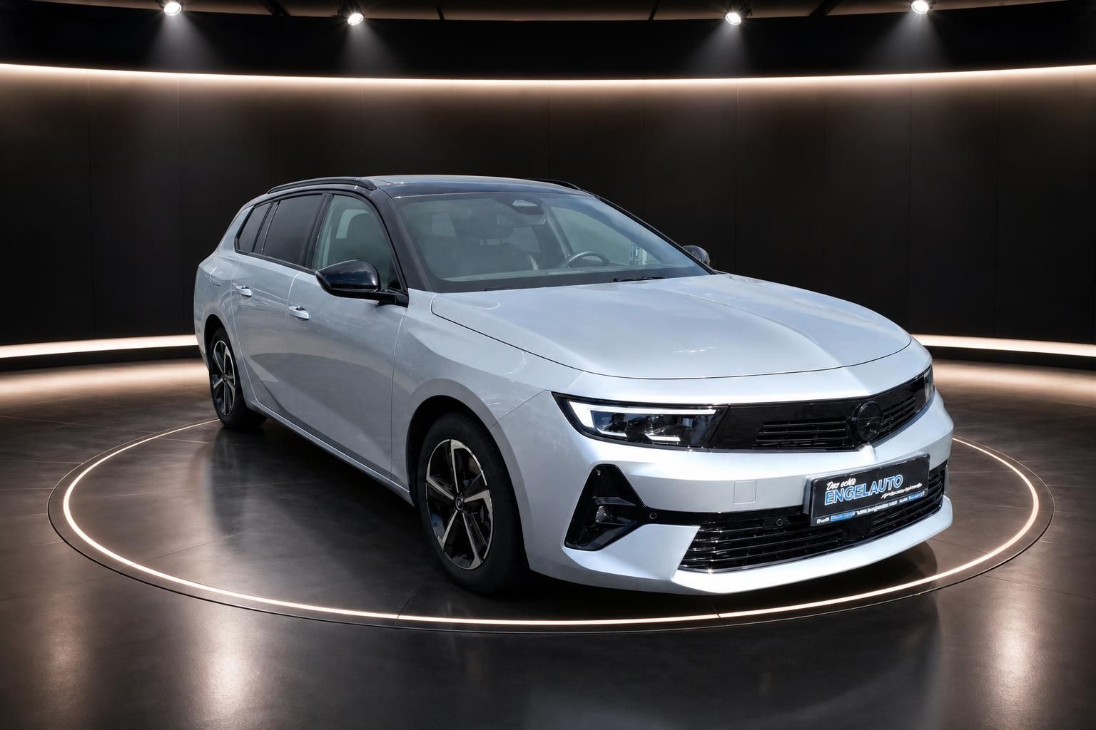 Weißer Opel Astra Kombi in modernem Showroom - Seitenansicht mit schwarzen Felgen und LED-Scheinwerfern