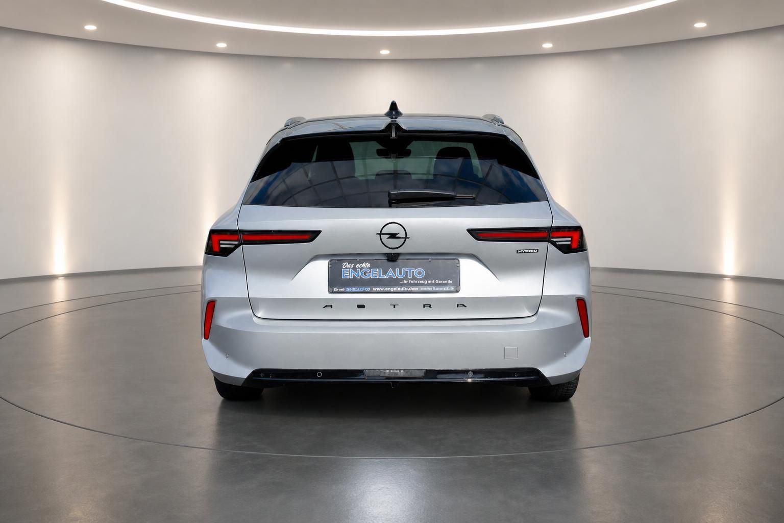 Opel Astra silber metallic Heckansicht im modernen Showroom - Hybrid Kombi Fahrzeug