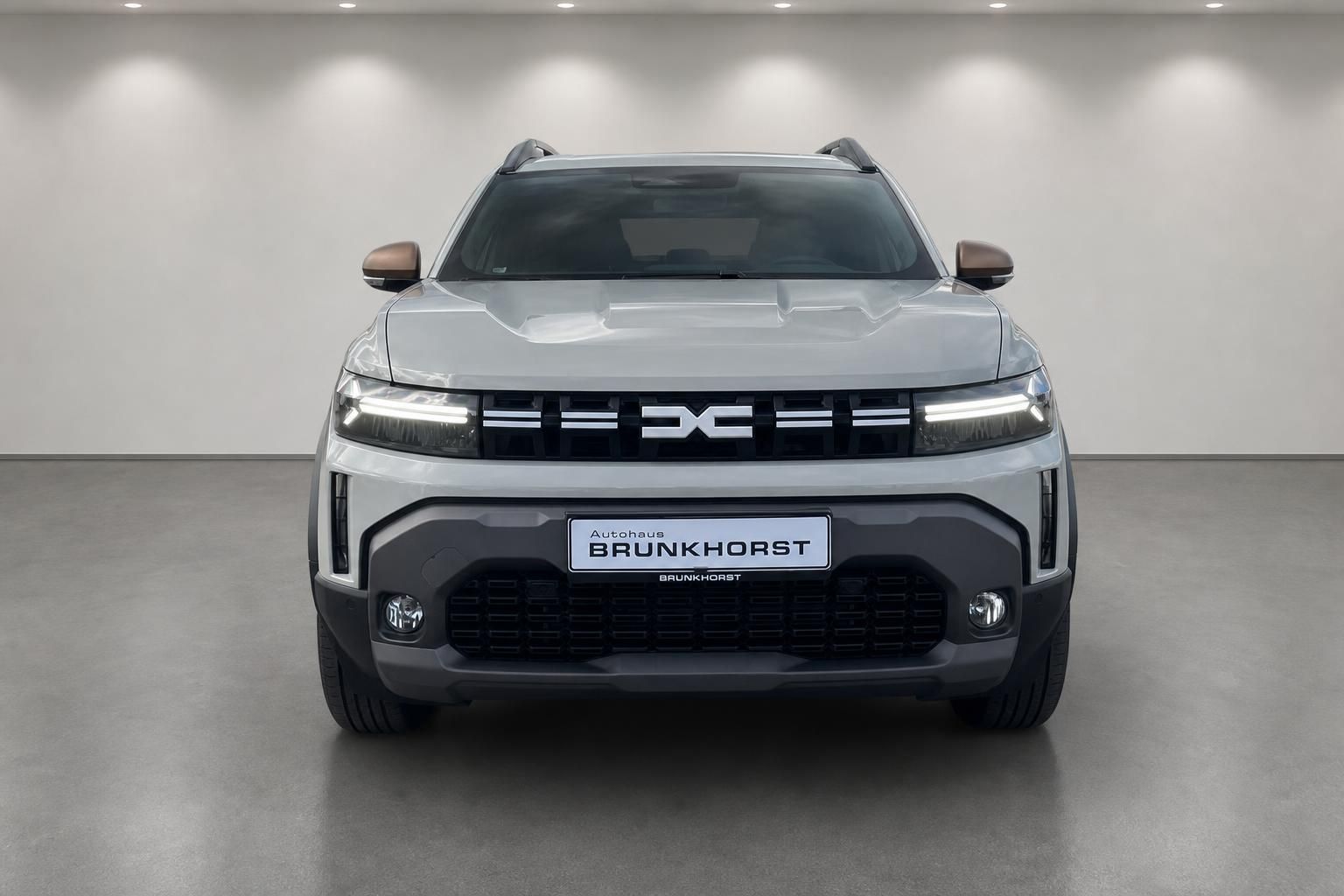 Dacia Duster SUV in weiss - Frontansicht mit Autohaus Brunkhorst Kennzeichen im Showroom