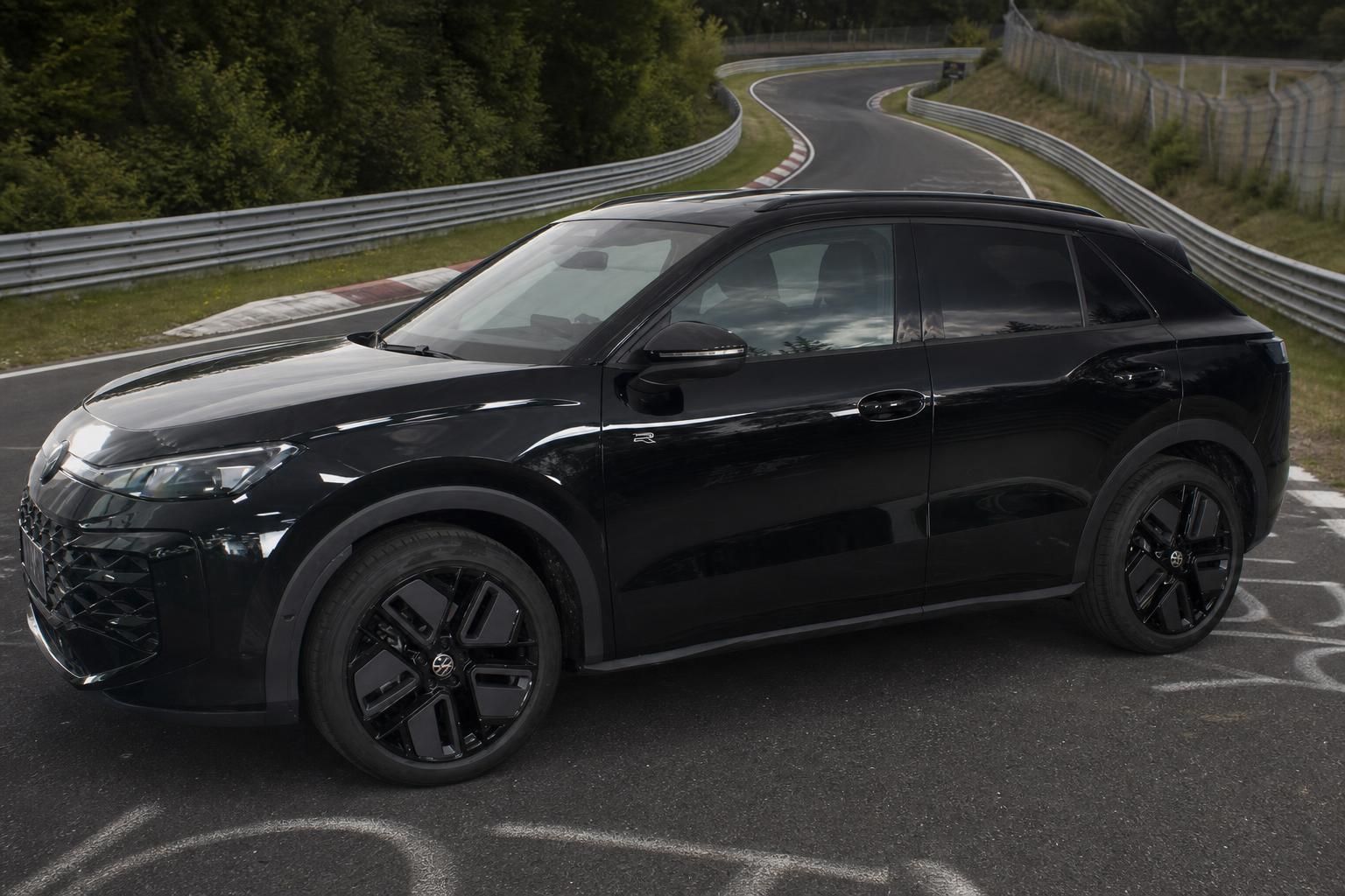 Schwarzer VW SUV R-Modell schräg von vorne auf Rennstrecke