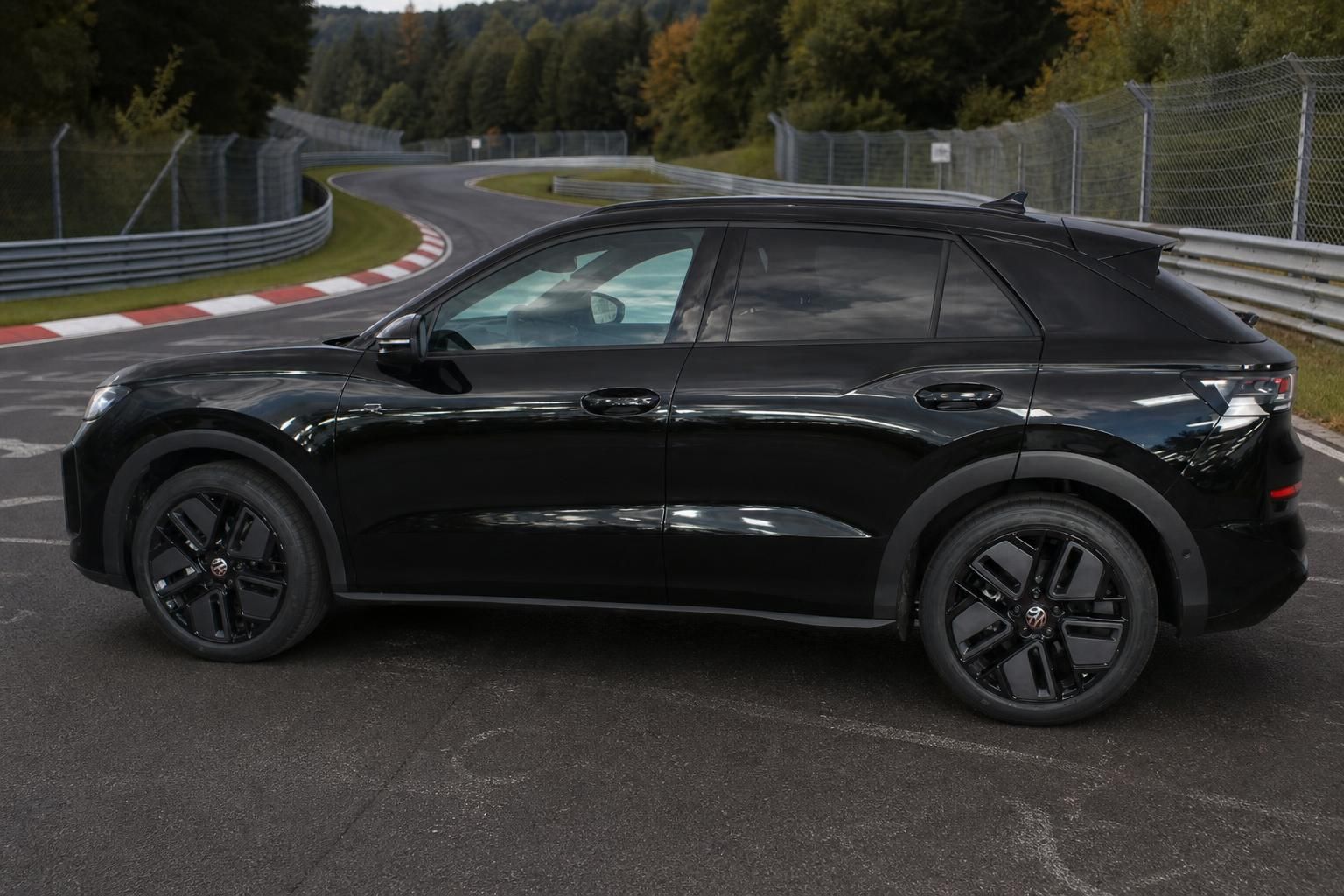 Schwarzer VW SUV Seitenansicht auf kurviger Nordschleife im Wald