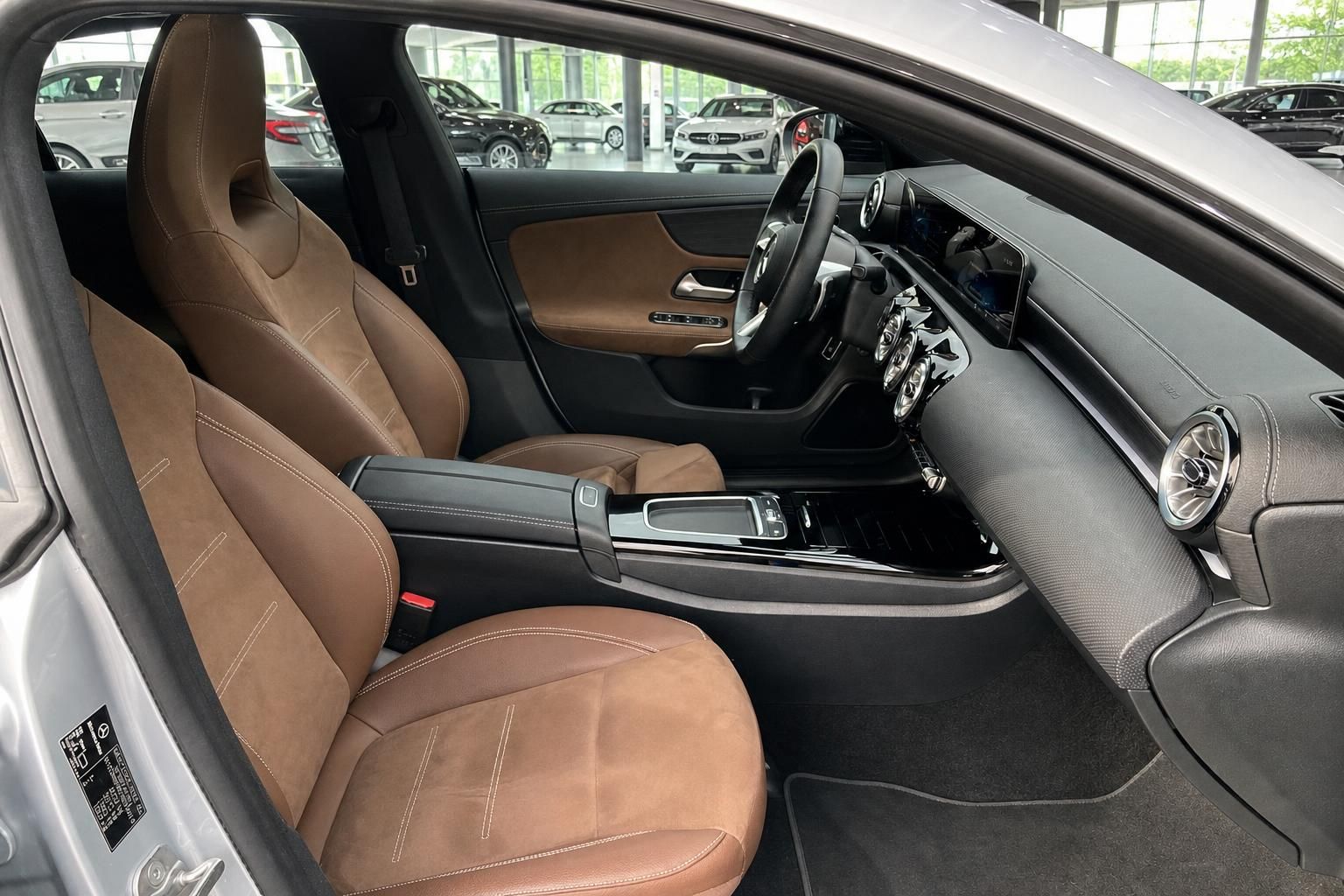 Fahrzeuginnenraum mit braunen Ledersitzen und modernem Cockpit Design
