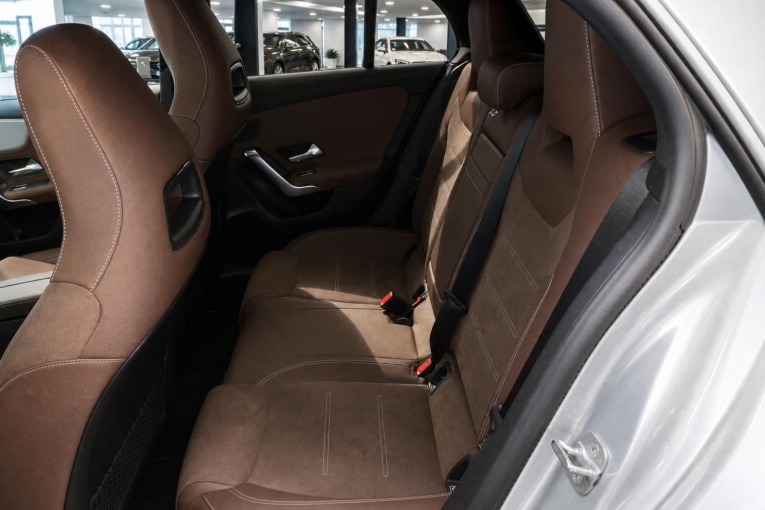 Rücksitze eines Mercedes-Benz mit brauner Lederausstattung und Sicherheitsgurten