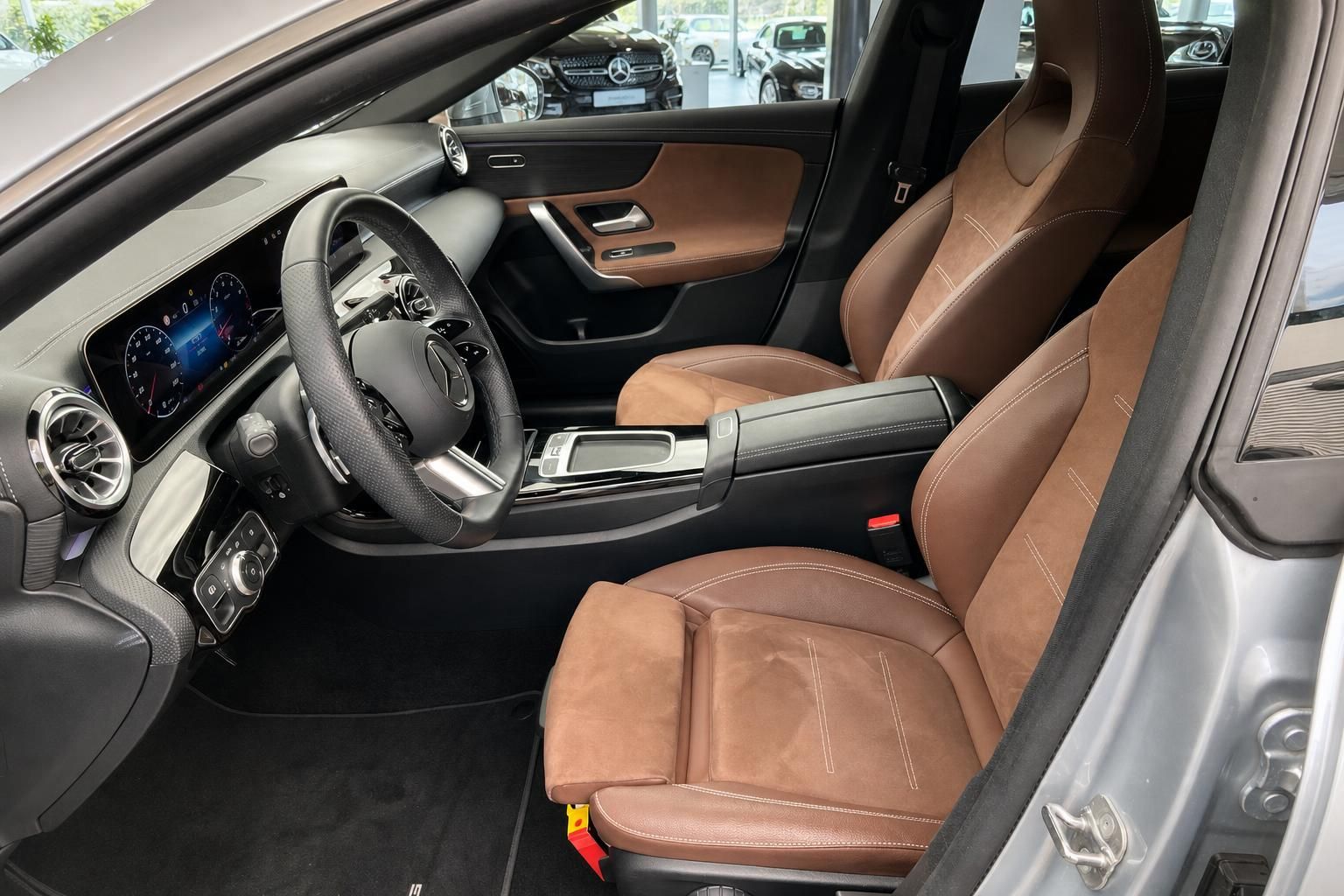 Fahrersitz und Cockpit eines Mercedes-Benz mit brauner Lederausstattung und Automatikgetriebe